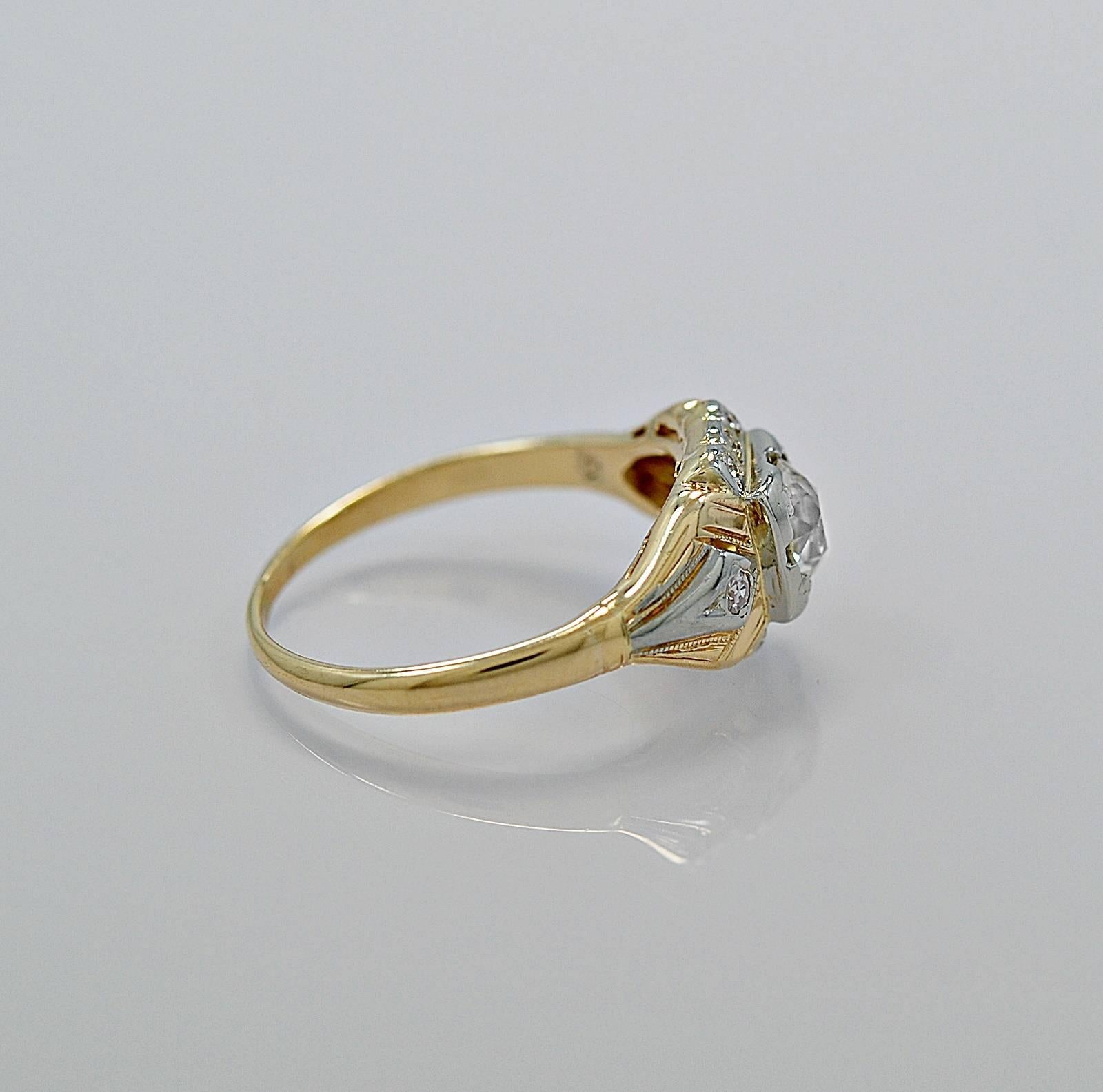 A wonderful antique engagement ring crafted in 14K white/yellow gold and features a .52ct. apx. European cut center diamond with I1 clarity (100% eye clean) and H-I color. The center diamond is set in white gold with trefoil prongs. There are .10ct.