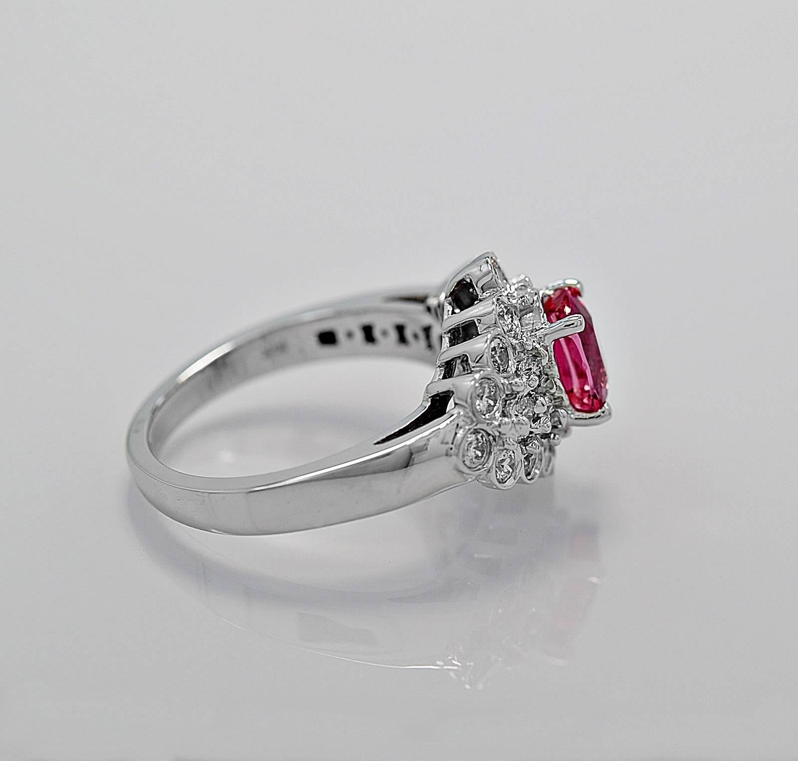 A bright and lively estate engagement ring or fashion ring with a natural & heated Padparadscha sapphire weighing 1.49ct. apx. and is surrounded with .60ct. apx. T.W. of round brilliant diamonds. It is crafted in 14K white gold and is beautifully