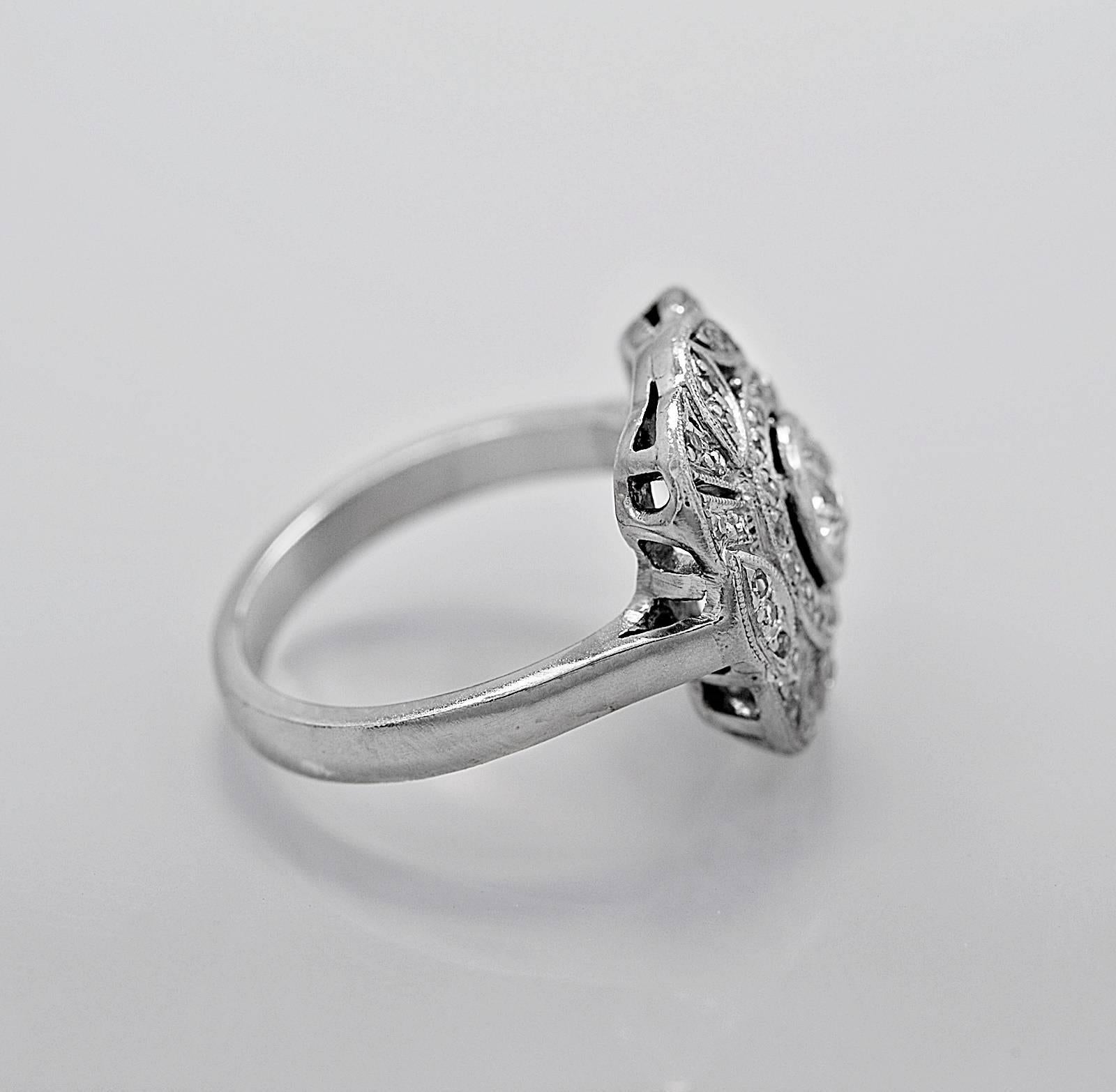 This is an original platinum Art Deco antique engagement ring - fashion ring featuring a center .60ct. apx. round European diamond with SI1 clarity and J color. The detailed filigree is accented with .25ct. apx. T.W. of round single cuts with G-H