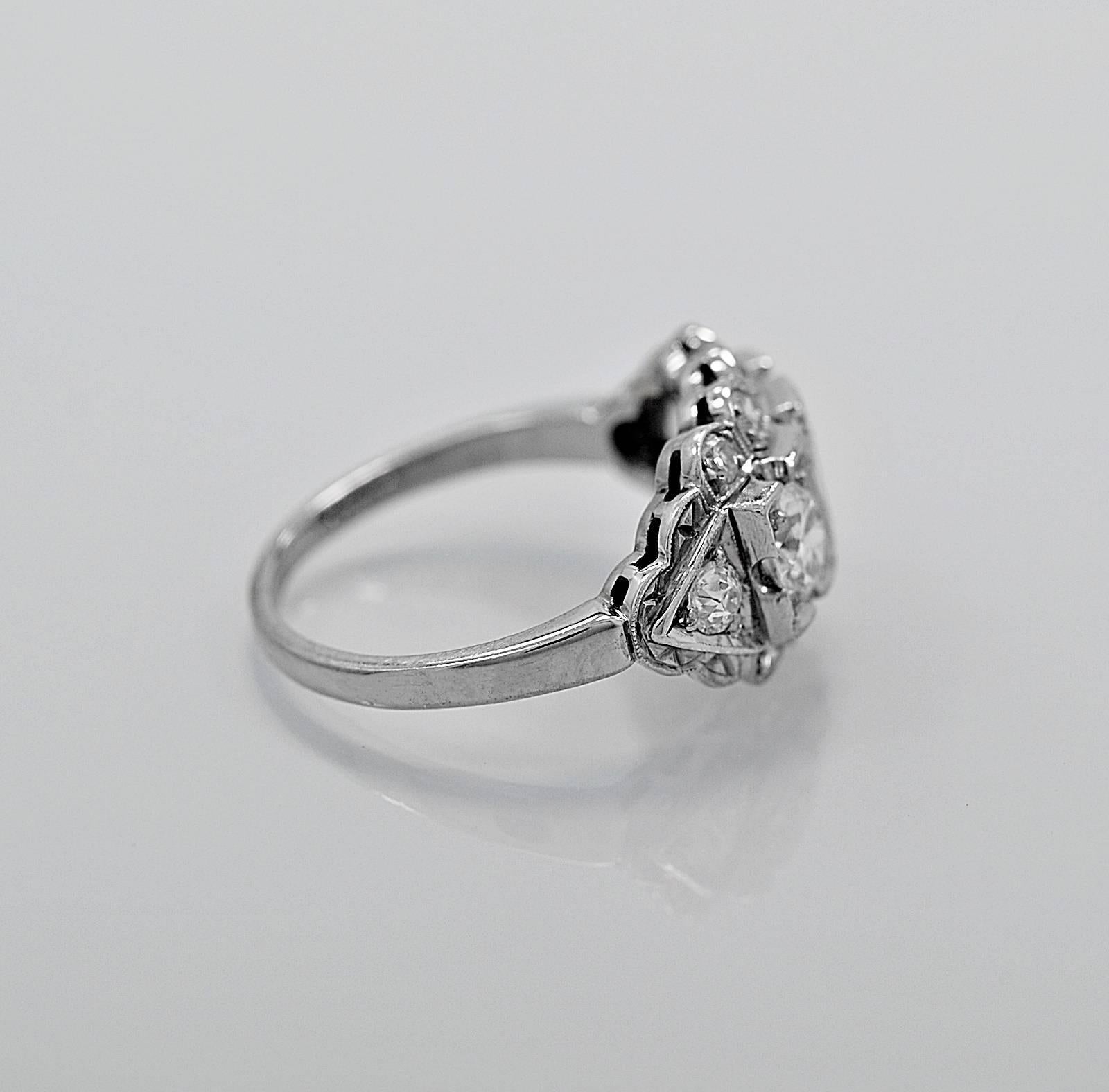 A stunning and blindingly brilliant Art Deco platinum diamond antique engagement ring. This ring features 3 center diamonds each weighing .38ct. apx., .38ct.apx. and .12ct. apx. = .88ct.T.W. apx. The surrounding .50ct. T.W. apx. diamond melee is