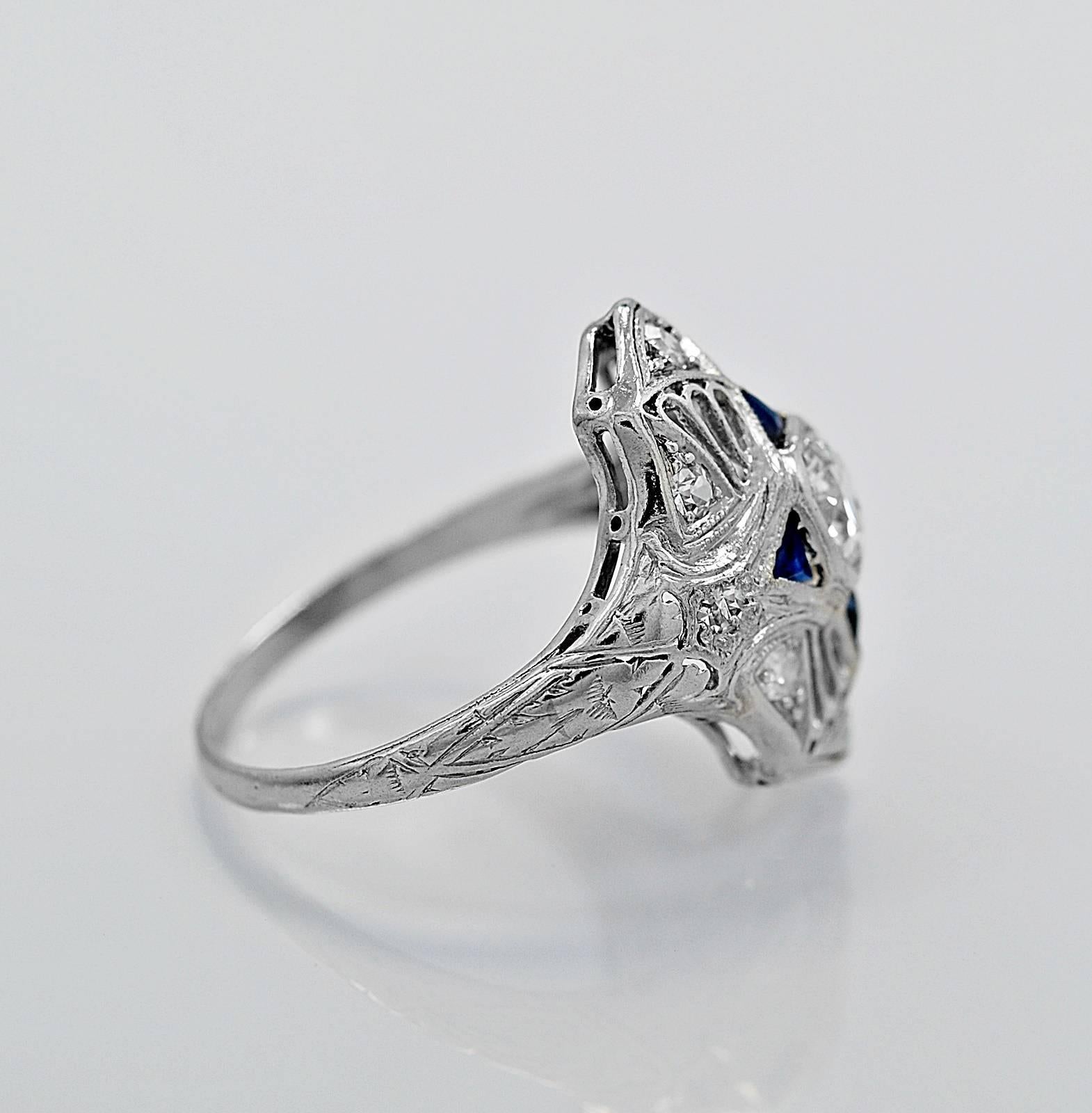 A wonderfully pierced, milgrain and engraved diamond, sapphire & platinum antique engagement ring or fashion ring from the Art Deco time period. It features a .40ct. apx. European cut diamond with G-H color and I1 clarity. Accented with .25ct. T.W.