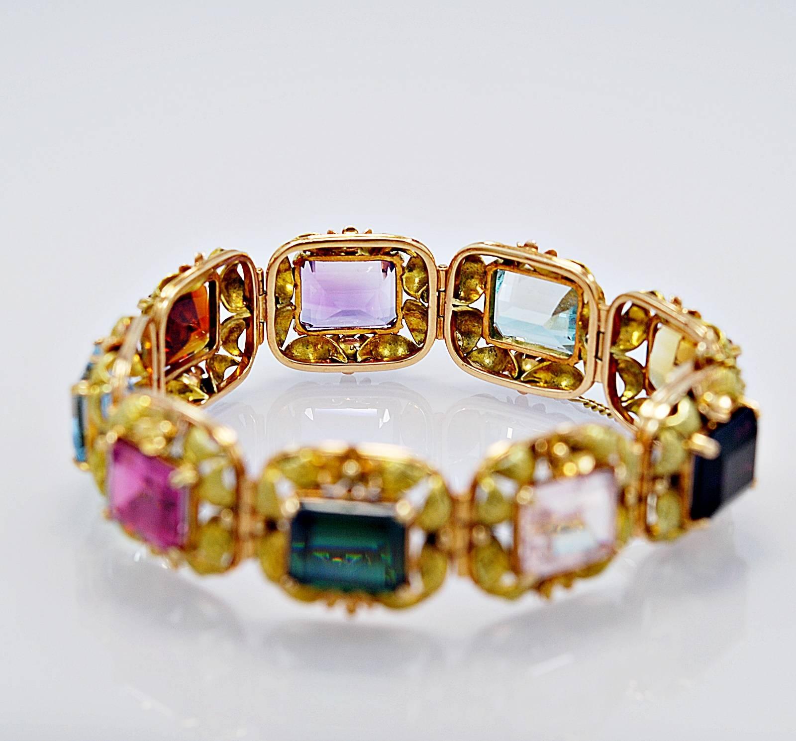 An extraordinary multi colored semi-precious stone estate bracelet featuring citrine, aquamarine, amethyst, orange citrine, pink and green tourmaline and kunzite. Each 12x10mm semi-precious stone is surrounded by 18K rose gold flowers and