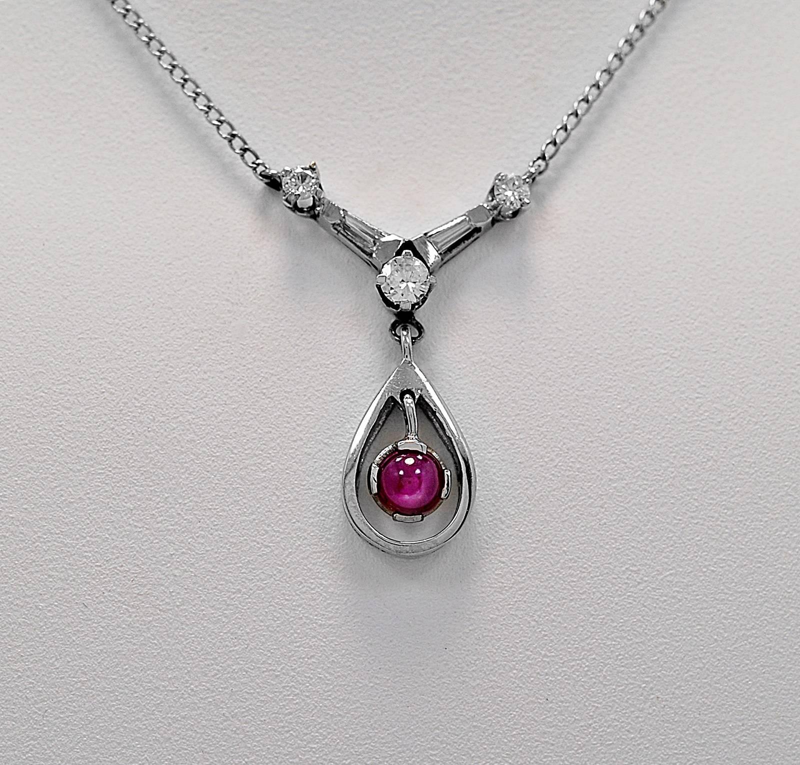 An exceptional estate pendant featuring a .75ct. apx. natural star ruby sapphire and .50ct. apx. T.W. of round brilliant and tapered baguette diamonds. The pendant is set in a 