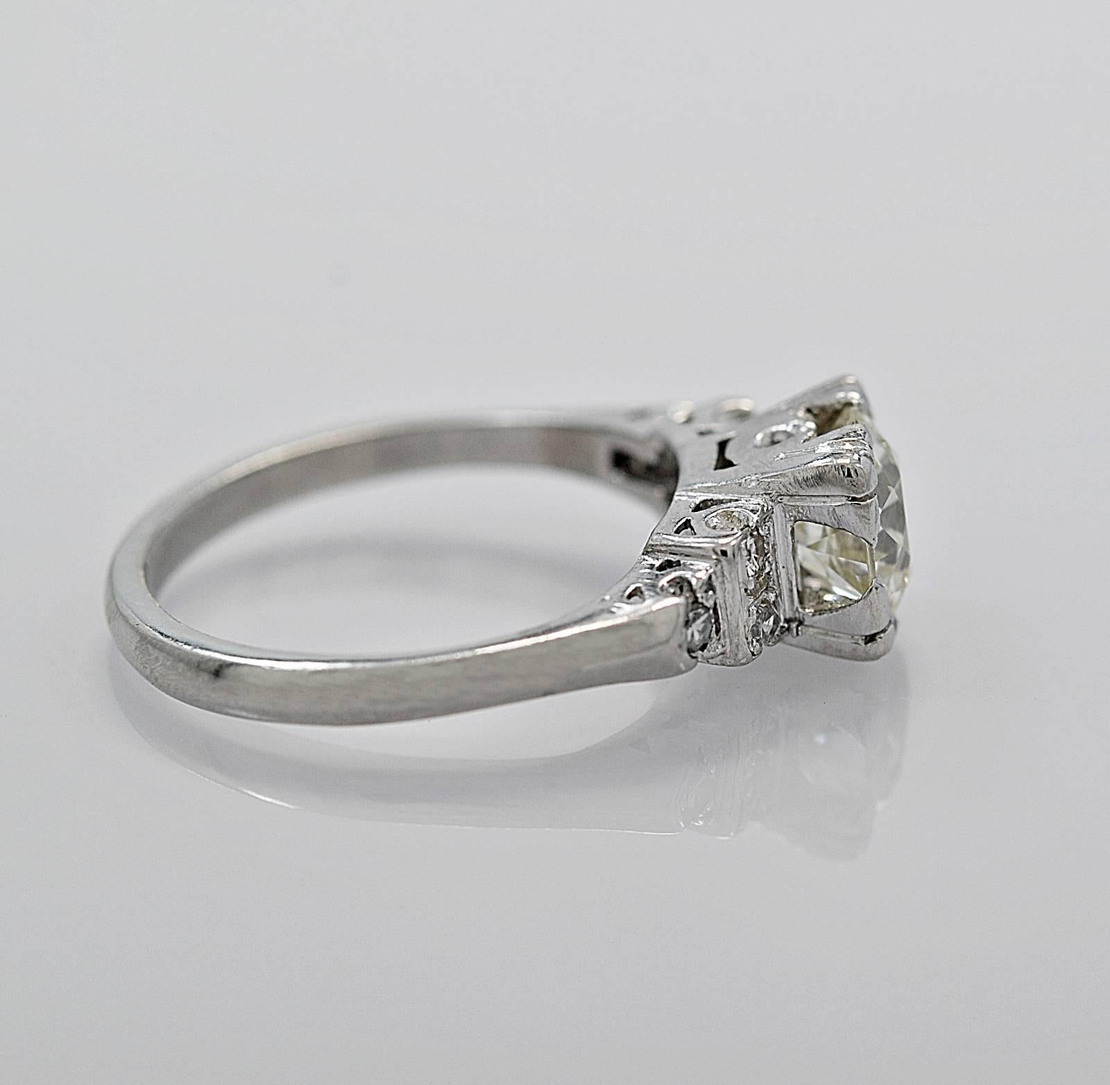 A dazzling antique engagement ring featuring a 1.31ct apx. European cut diamond with VS1 clarity and M color. It faces up very white. It has .06ct. apx. T.W. of single cut diamond melee decorating the sides of the center stone. This ring makes a