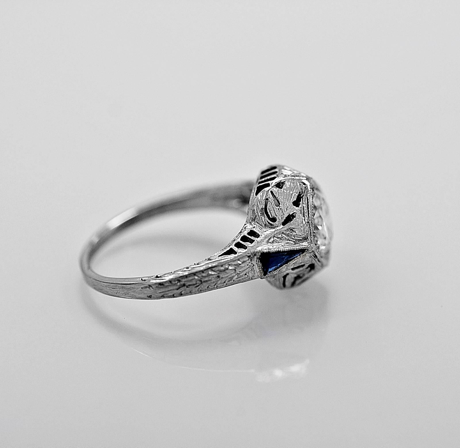 A beautiful antique engagement ring featuring a .75ct. apx. European cut center diamond with VS2 clarity and H color. It also has .16ct. apx. T.W. of synthetic blue sapphires (consistent with the time period). The center diamond is surrounded by