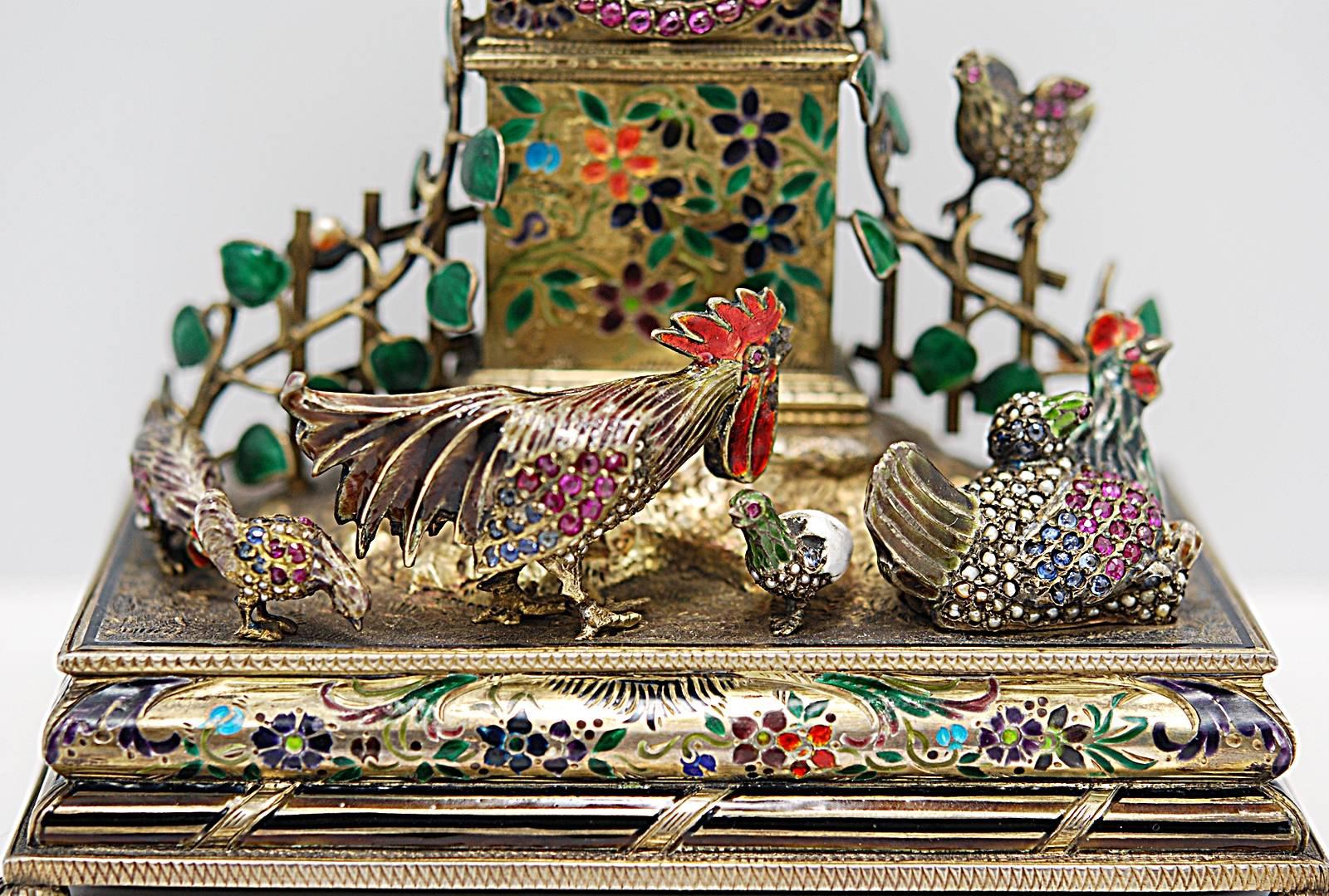 A gorgeous Viennese jeweled silver gilt Tower clock with an active barnyard scene in the foreground. The chickens are decorated with seed pearls, natural cabochon rubies and sapphires. The base of the clock tower is beautifully decorated with