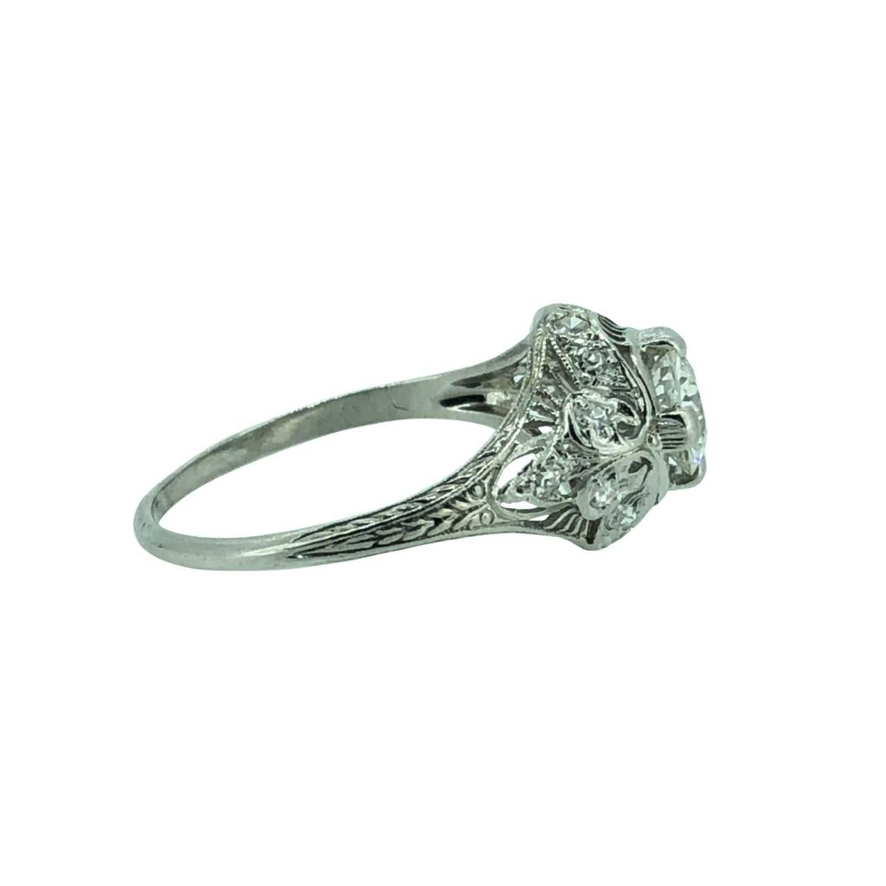 Easily one of the prettiest antique diamond engagement rings we have. This platinum engagement ring features a .60ct. apx. european cut diamond with VS2 clarity and G color. The accenting .33ct. apx. T.W. of single cut melee decorate the mounting,