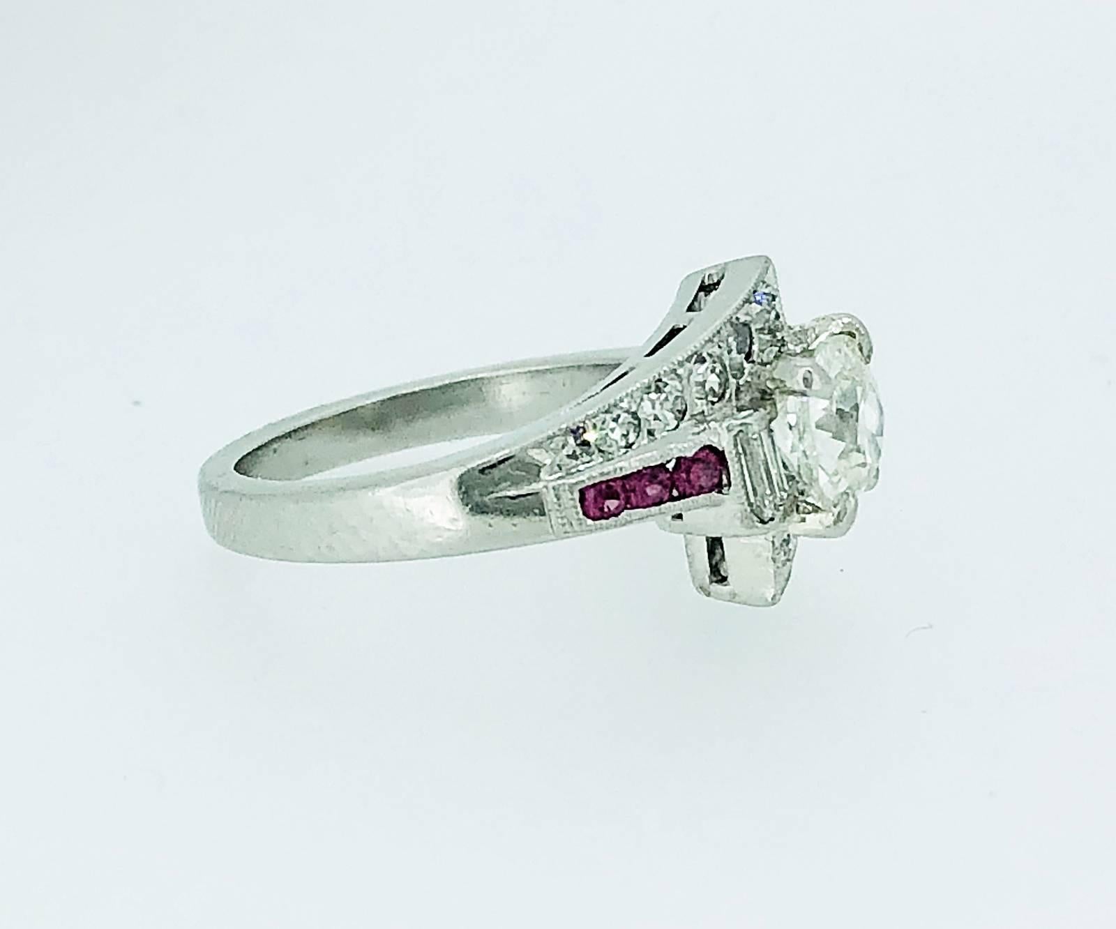 A fabulous Art Deco diamond and pink sapphire Antique engagement or fashion ring that features a 1.03ct. apx. sparkling European cut diamond with J color and SI1 clarity. Accenting the center diamond are .25ct. apx. T.W. of single cut diamonds with