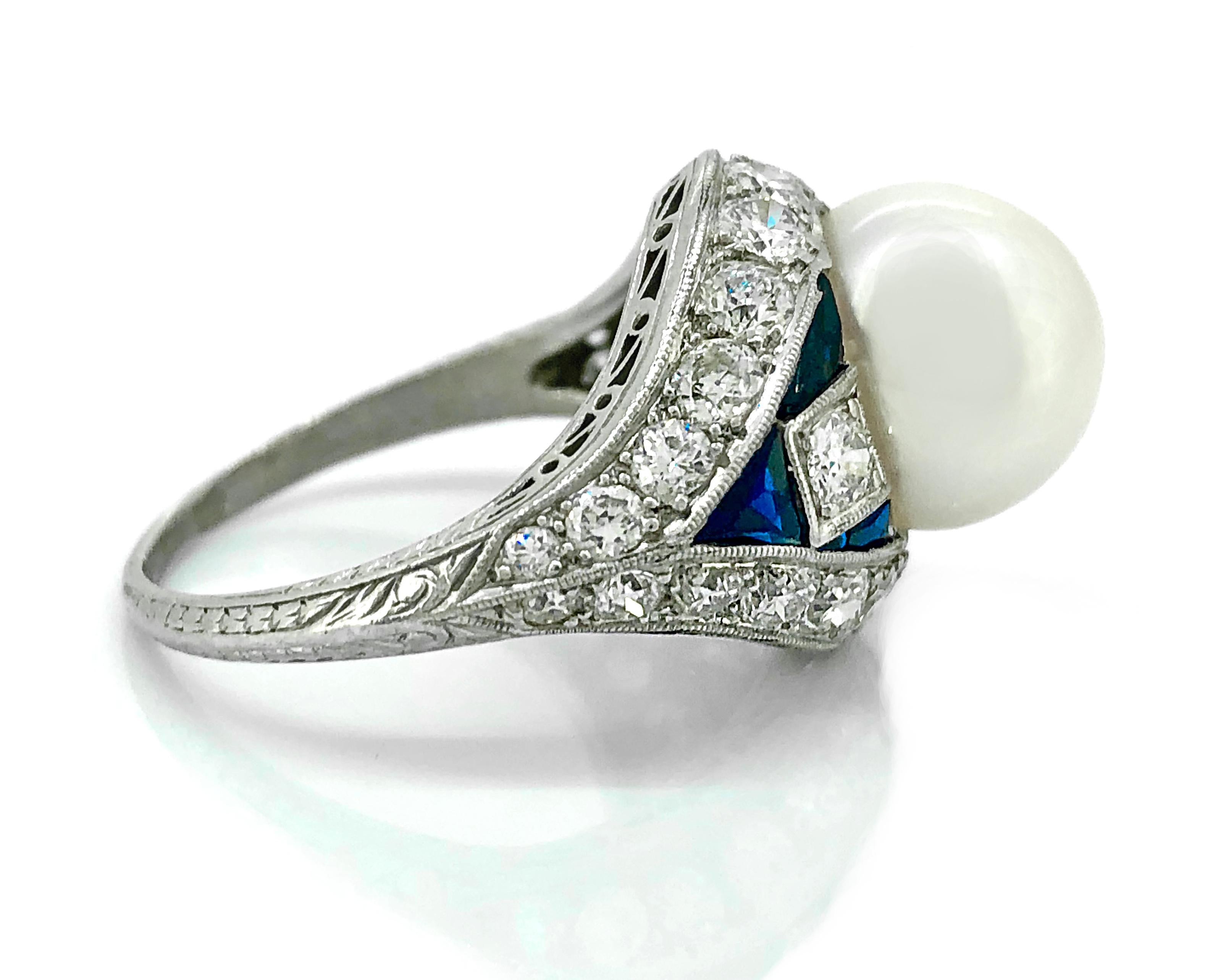 An extraordinary alluring Art Deco pearl, diamond and sapphire Antique engagement or fashion ring featuring a 10.1mm Akoya pearl, 2.25ct. Apx. T.W. of European cut diamonds with VS2-SI1 clarity and G-H color, as well as .75ct. Apx. T.W. of synthetic