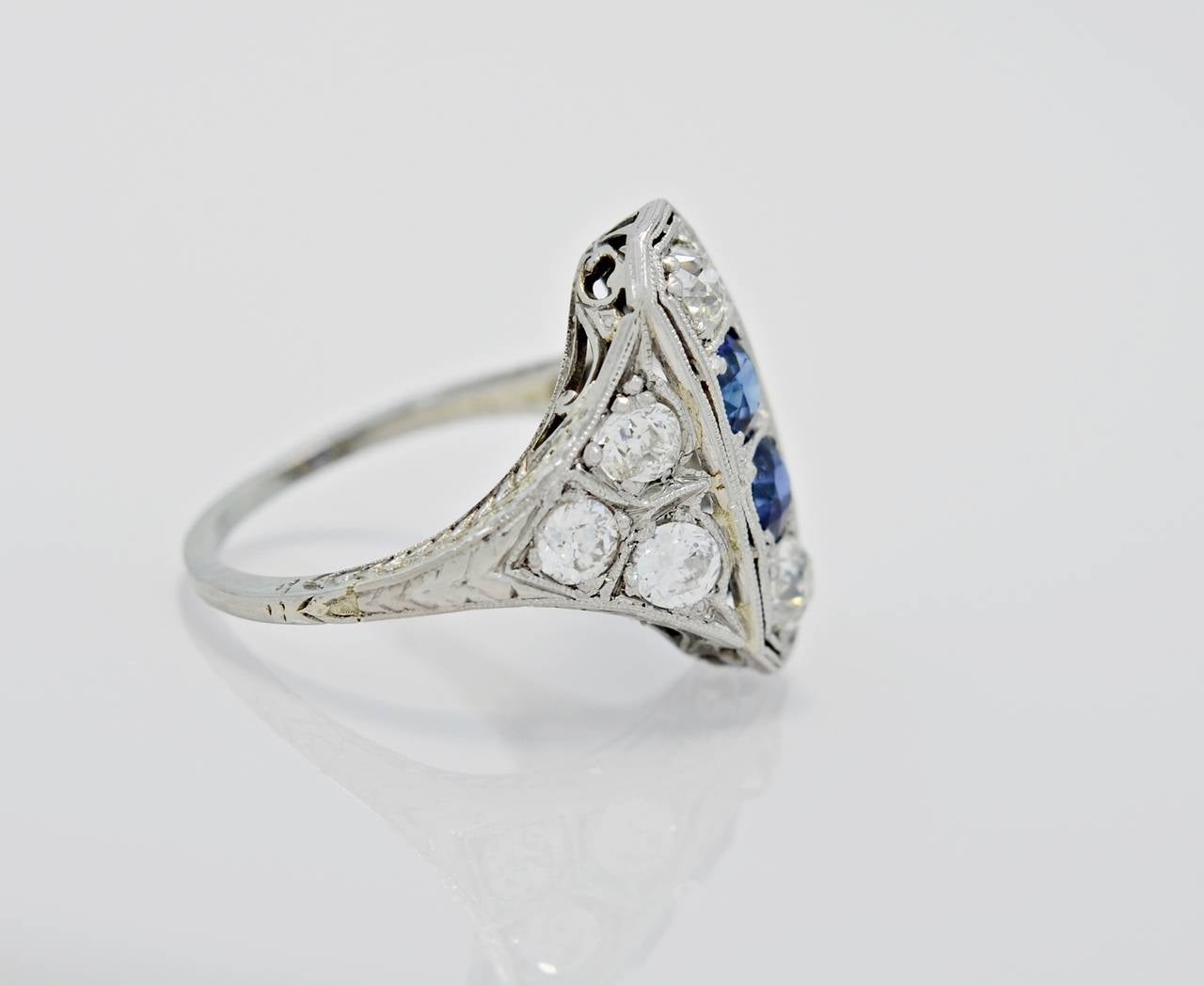 This is an elegant Art Deco fashion ring featuring scintillating 1.05ct. apx. T.W. European cut diamonds and .75ct. apx. T.W. of brilliant blue sapphires. This very special ring has beautiful millegrain bead work encircling the center diamonds and