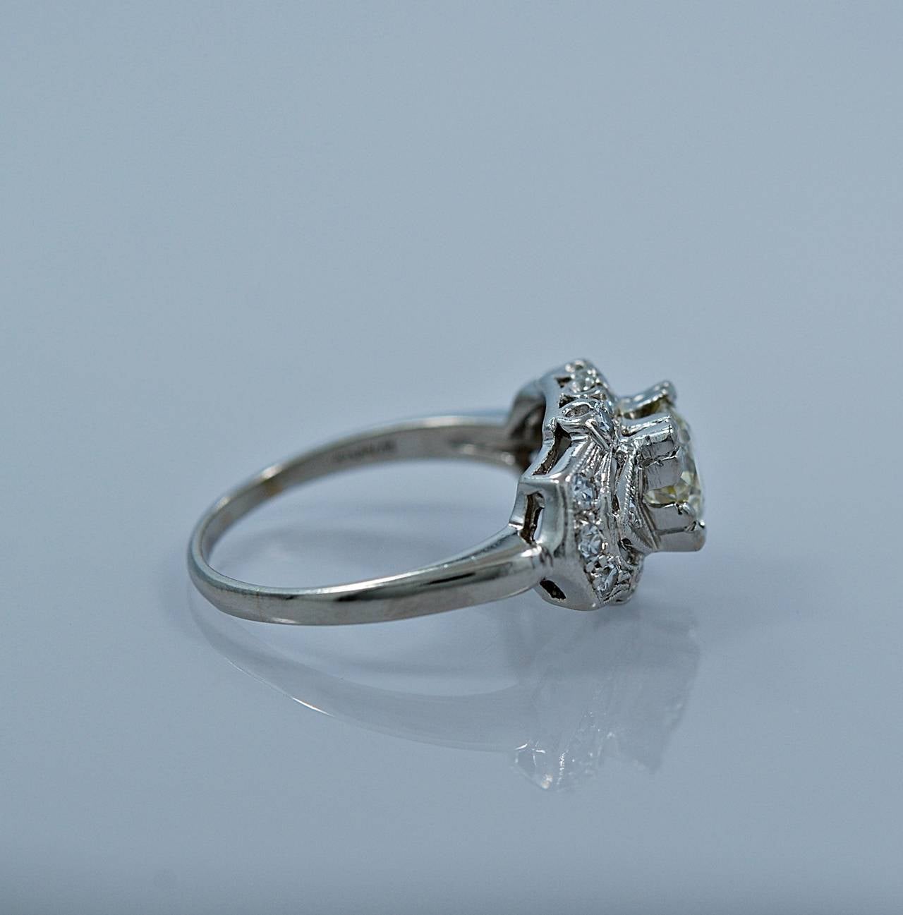 A beautifully designed Art Deco diamond engagement ring crafted in platinum and features a 1.00ct. apx. European cut diamond of VS1 clarity and J-K color. The center diamond is also accompanied by .33ct. apx. T.W. of diamond melee which adds