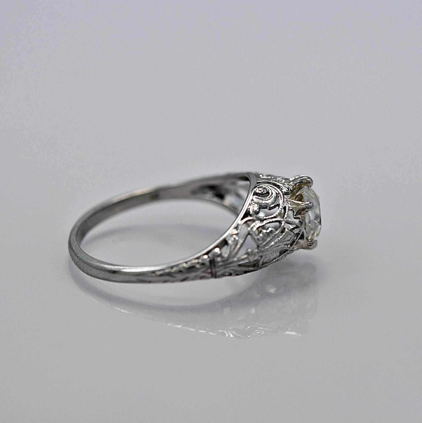 An absolutely fabulous Edwardian diamond engagement ring crafted in platinum featuring a 1.40ct. apx. European cut diamond with VS1 clarity and I-J color. The mounting is artfully ornamented with decorative piercings, scroll work and engraving. This