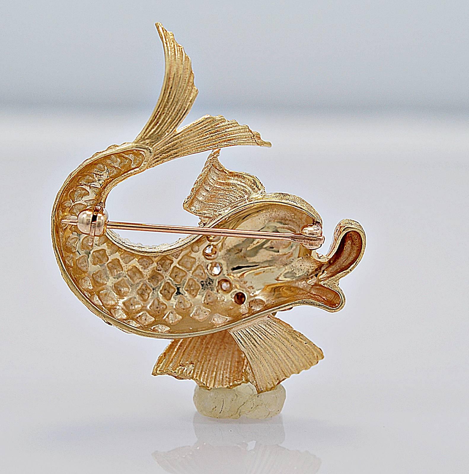 This is a stunning and decorative 14k yellow gold diamond brooch featuring a playful fish that is accompanied by .15ct. T.W. apx. of diamond melee with VS-SI clarity and H color. The brooch is a perfect size for a blouse or jacket. Lovely!