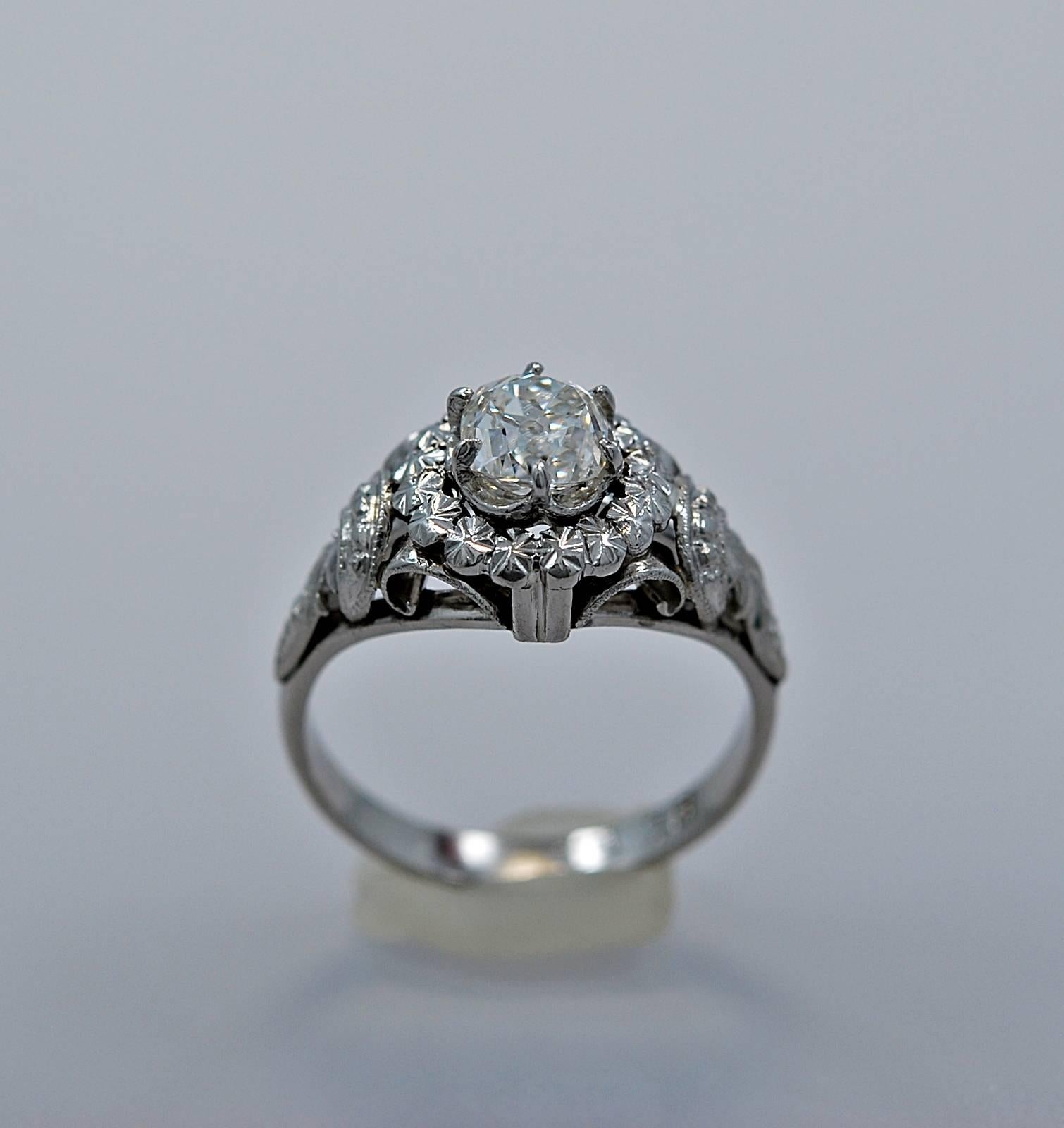 An Art Deco diamond engagement ring crafted in platinum. This ring features a .85ct. apx. diamond of SI2 clarity and H-I color. This is a fantastic ring in its design. It exhibits scroll work, wonderful piercing, milgrain and small flowers