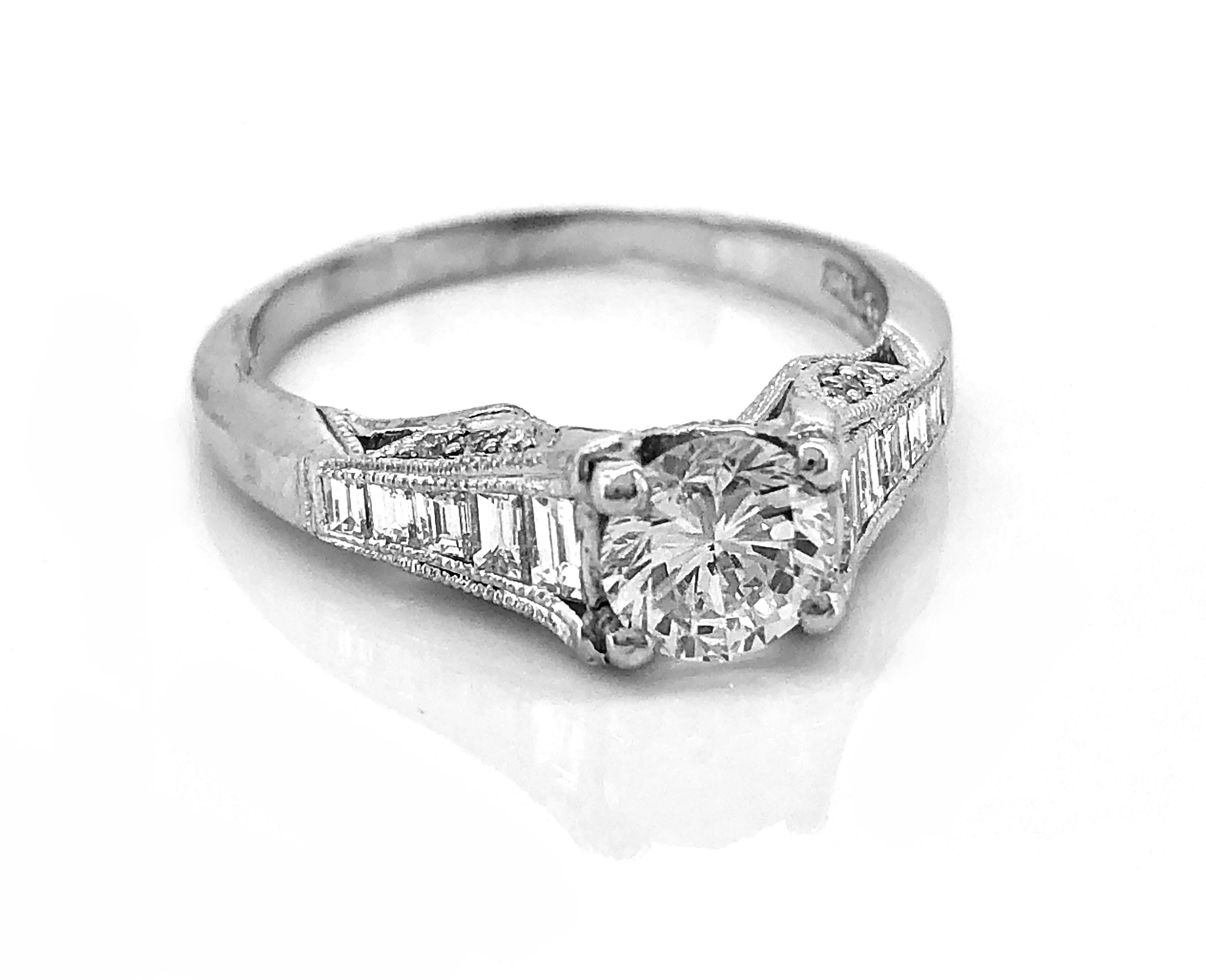 From the world renowned Tacori Company, this platinum engagement ring features a .73ct. apx. round brilliant diamond with excellent quality and has VS1 clarity and F color. The accenting diamonds, both emerald and round brilliant cut melee, weigh