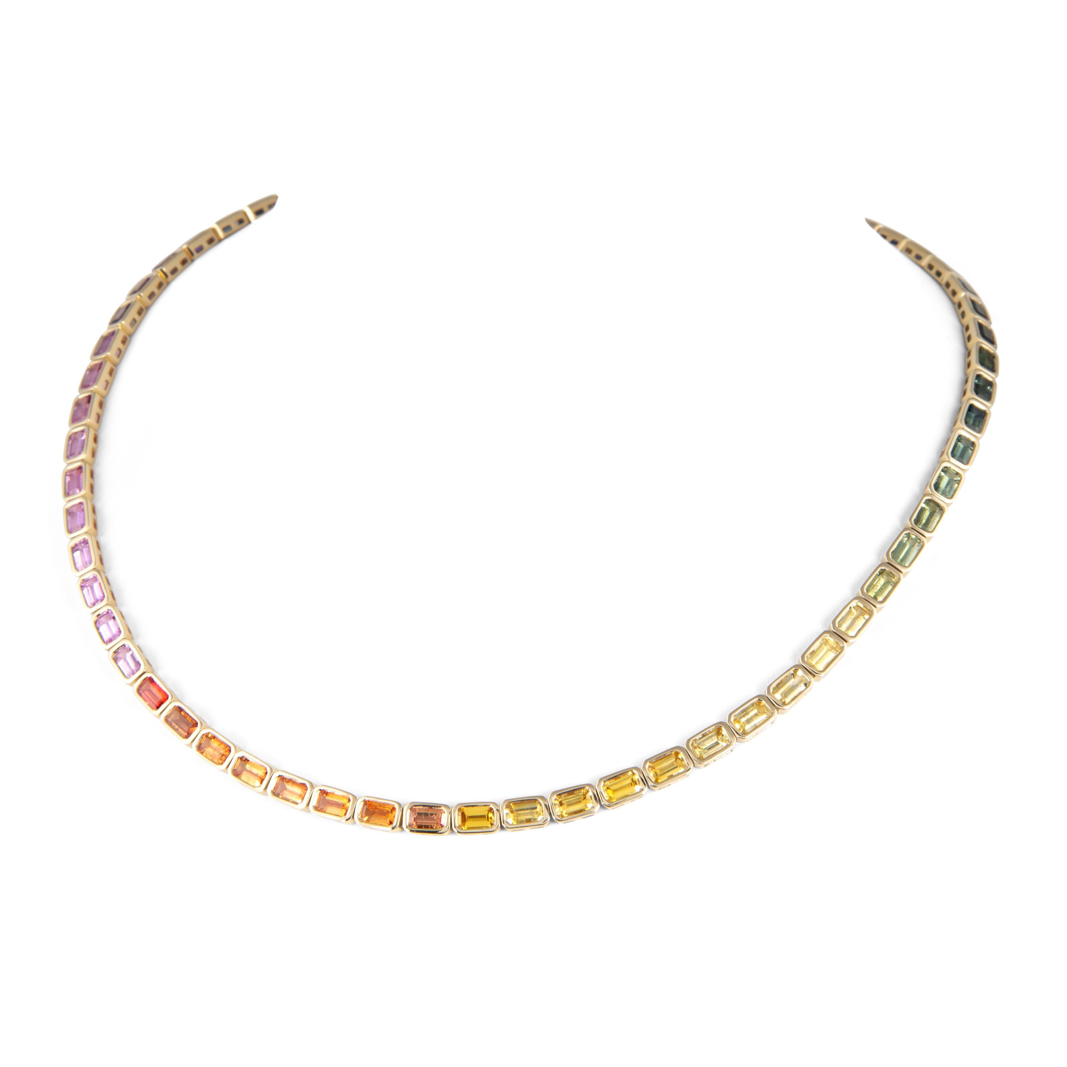 Exquisito y perfectamente graduado collar de tenis de zafiros naturales talla esmeralda arco iris multicolor engastados en bisel, de Alexander Beverly Hills.
58 zafiros talla esmeralda, calor, 17,85 quilates en total. Bisel engastado en oro amarillo