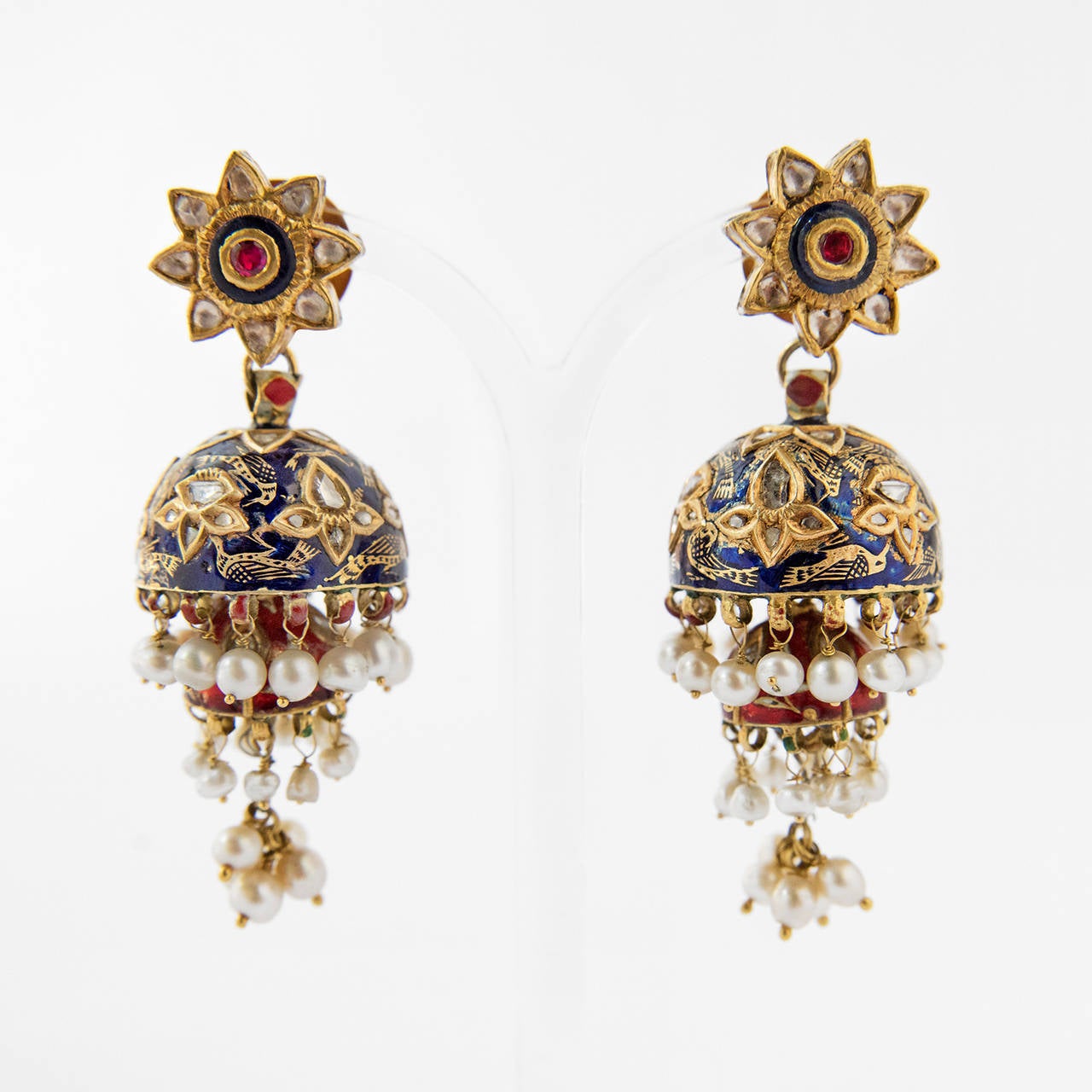 A pair of gold ear pendants, KARN PHUL JUMKHA, suspended a dome shape pendant, decorated with darkblue Nil Zamin enamel. From this a smaller JUMKHA is hung, decorated with red Lal Zamin enamel. The JUMKHAs are kundan set with diamonds in a floral