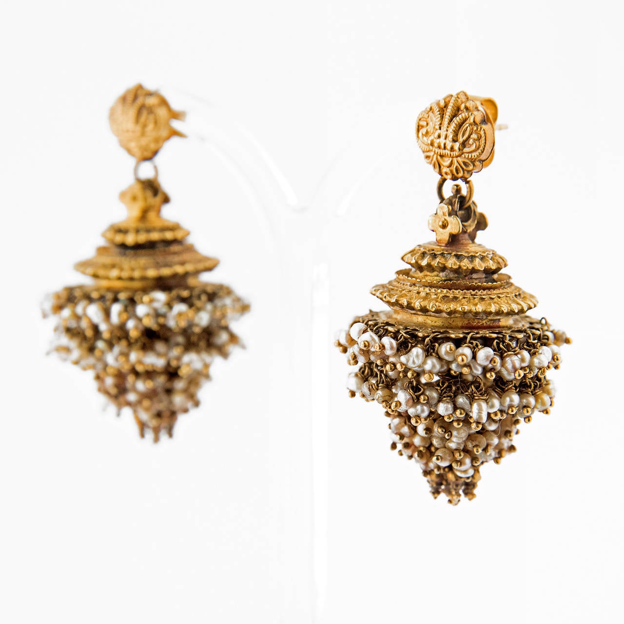 A pair of gold ear pendants, GINTILI with JHIMKi, consisting of a small top, and suspended dome shaped  pendant, JHIMKI, decorated with granulation and hung with bunches of small pearls. India, Andhra Pradesh / Karnataka (Mysore), ca 1900

Andra