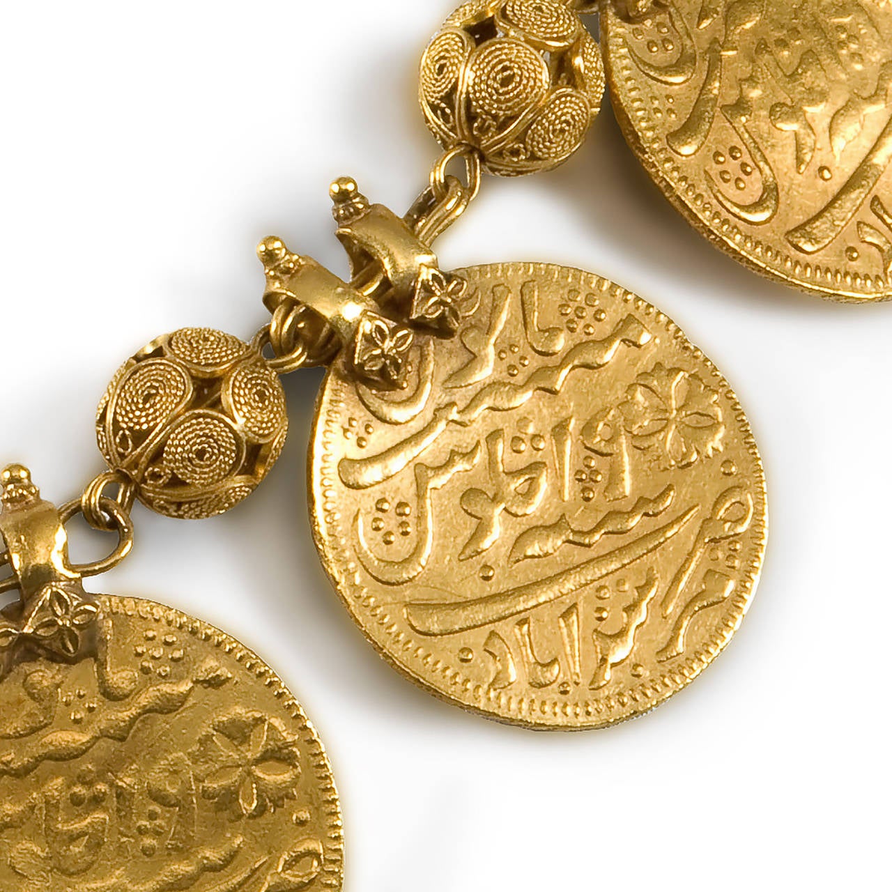 A gold necklace, KASU MALAI, consisting of nine auspicious coins separated by open worked, linked gold spacers. The coins have Urdu inscriptions on either side. India, early 20th Century

This type of necklace can be traced back to the Rig Veda,