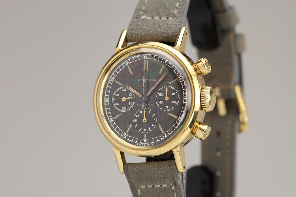 This is an exceptional and extremely rare example of a Movado chronograph in 18k yellow gold from the 1940s. The original black dial of this watch is in mint condition and has a beautiful mirror finish. The case is also mint with the same buttons as