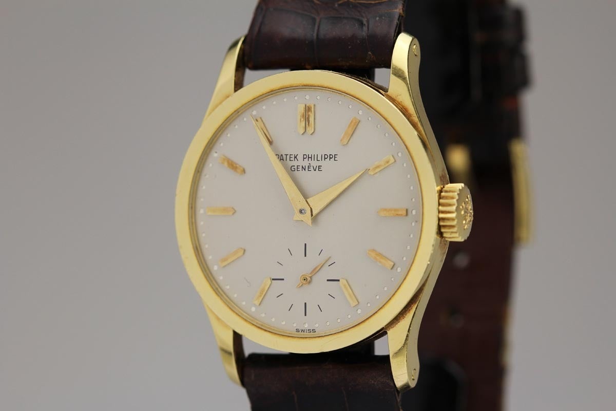 Patek Philippe 18k yellow gold Calatrava wristwatch, Ref. 96, silvered dial with pointy baton markers, snap-back case, manual-wind movement, comes on a dark brown Patek Philippe leather strap with 18k yellow gold tang buckle.