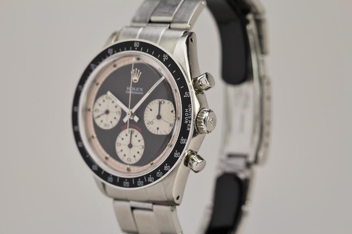 This is an exceptional example of a Rolex Cosmograph known as the Paul Newman Daytona. This is a highly sought-after reference 6241 with the attractive combination of a black acrylic bezel and three color minty black dial.