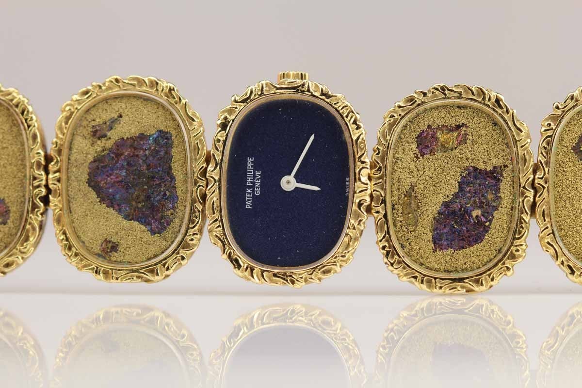 A unique lady's Patek Philippe wristwatch in 18k yellow gold with a stone called Iridescent Chalcocite.  Dial, case and movement signed. Dim. 18 x 23 mm. Thickness 6 mm. Approx. overall length 7
