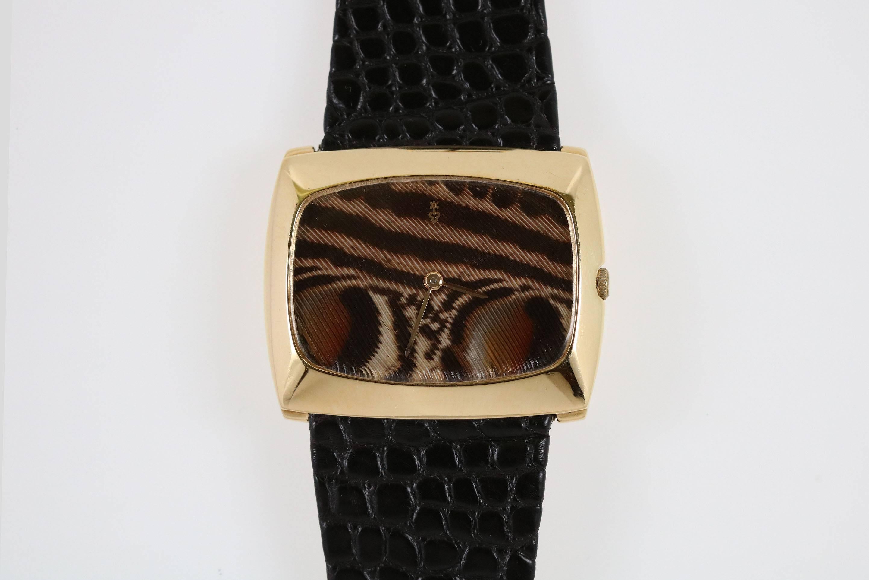 This is a classic 1970's Corum "Feathered Friend" wristwatch in yellow gold with a bird feather dial. Comes on a Corum strap and buckle.