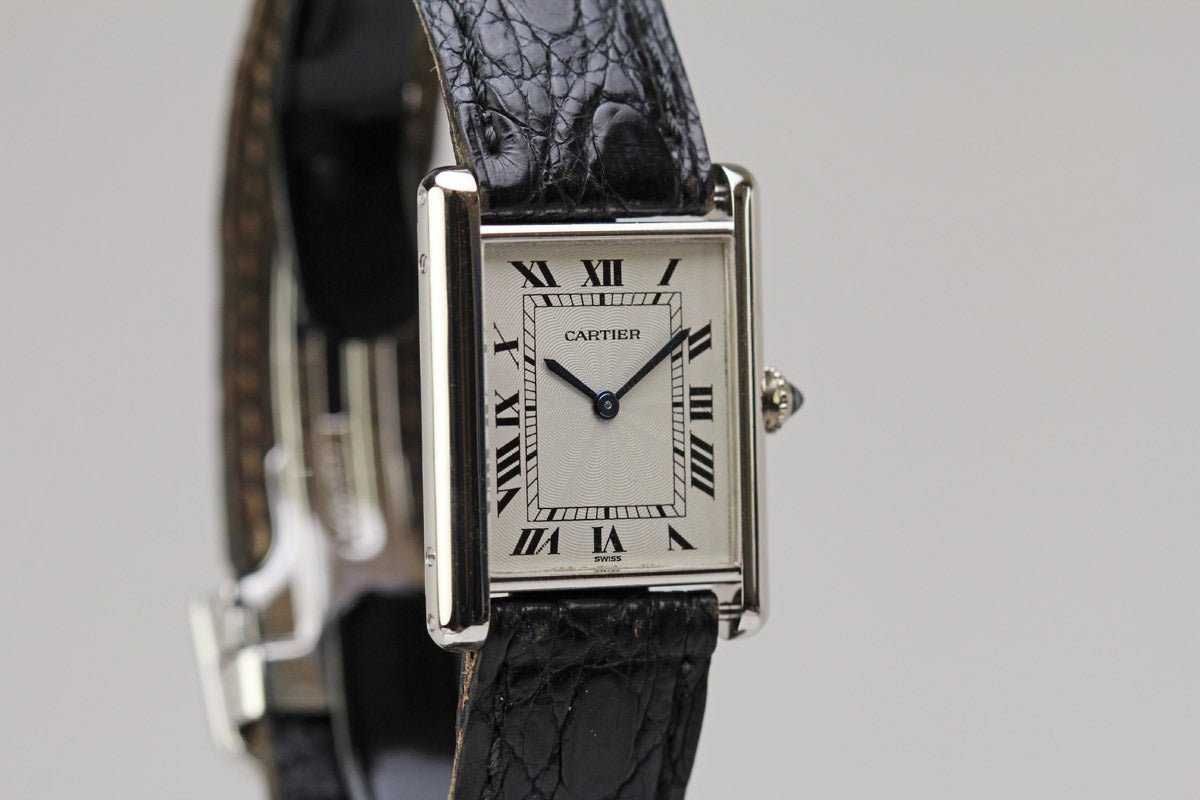 This is an elegant Cartier Tank Louis from the 1990's in platinum on a black leather strap with a Cartier deployant clasp.