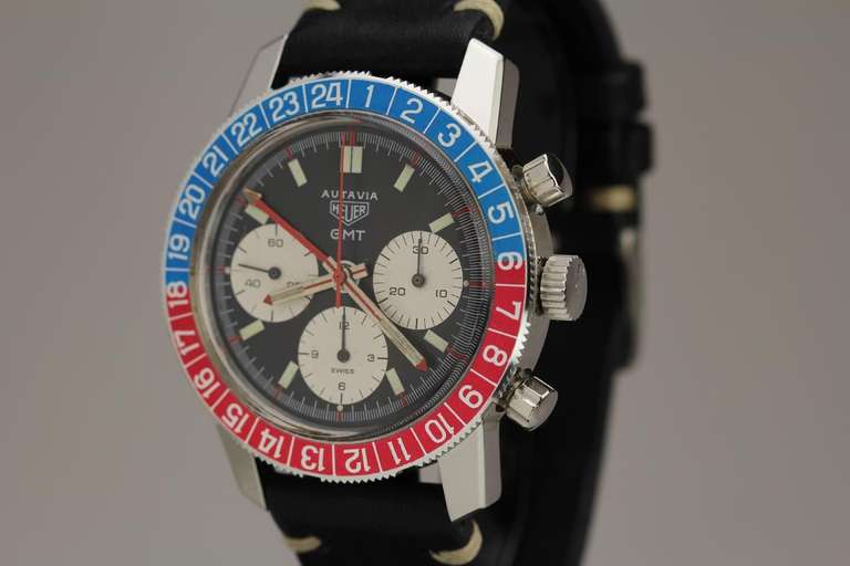 This is a stainless steel Heuer Autavia GMT chronograph with a blue/red rotating bezel, three chronograph registers, pump pushers, red hand with yellow arrow GMT hand. It is an excellent example with an original dial and a beautiful GMT bezel.