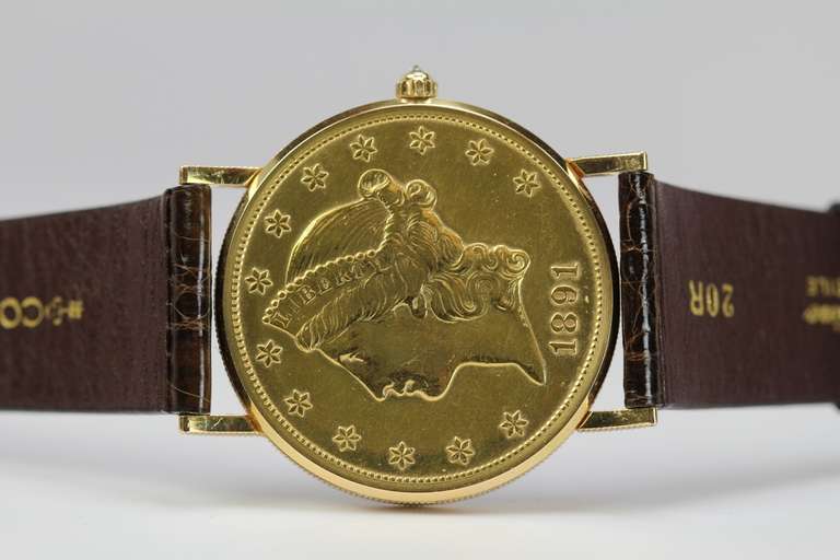 This is a discontinued Corum 18k yellow gold wristwatch, the dial is an 1891 Eagle $20 gold coin with time and date. It has a quartz movement, comes on an original Corum strap and 18k gold Corum buckle.