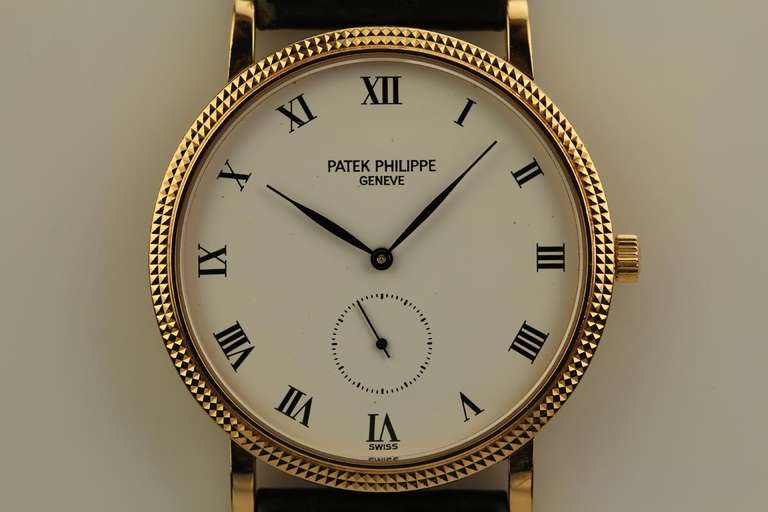 Patek Philippe 18k yellow gold Calatrava wristwatch, Ref. 3919, with hobnail bezel, white dial with subsidiary seconds, manual-wind movement, on a Patek Philippe leather strap and 18k yellow gold buckle.