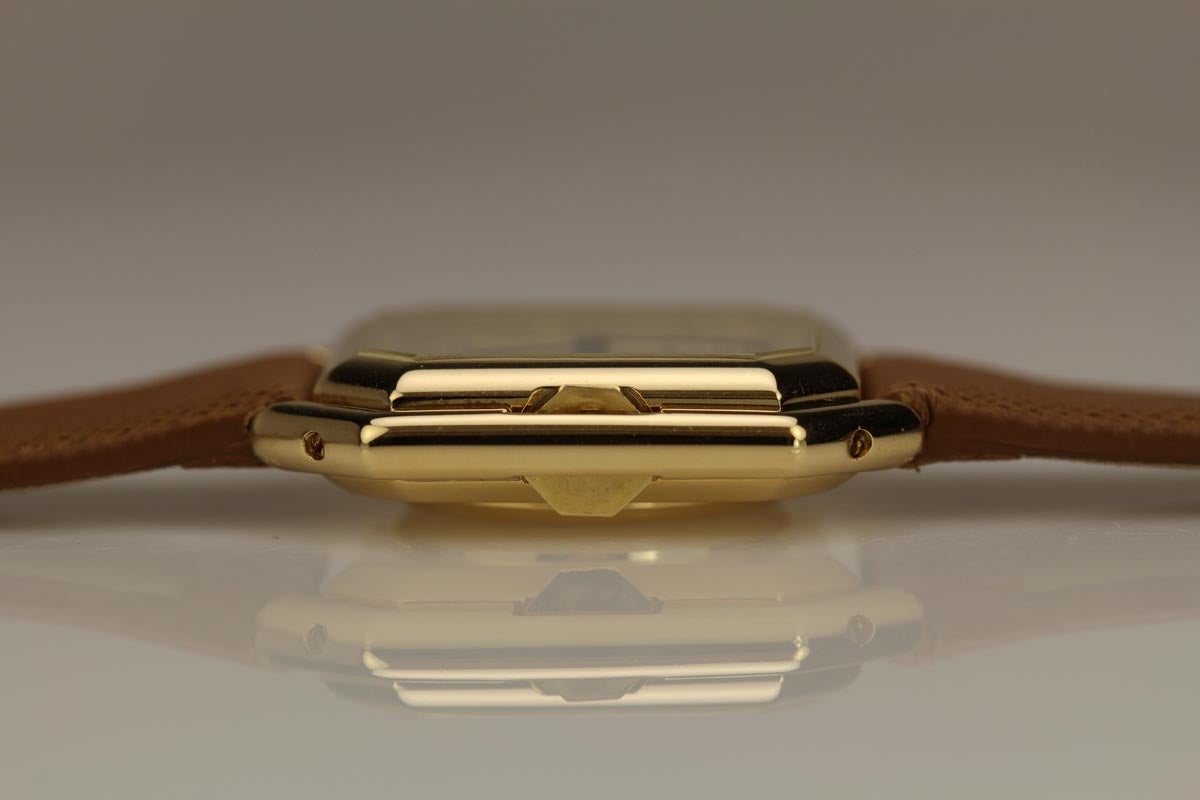 Timeless Cartier Ceinture with a octagonal case in yellow gold. The stepped case features a graceful crown guard and original cream dial. This is 1980's wristwatch is run with an automatic movement.