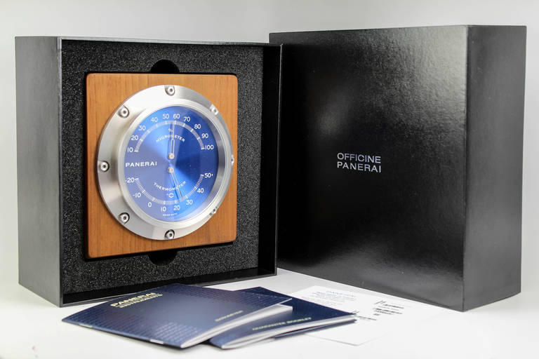 Panerai Pam 256 hygrometer thermometer teak wood desk instrument with blue dial. This is unused and Includes outer box, inner box, stickers, instructions and undated warranty card. Measurement is approximately 6 inches square