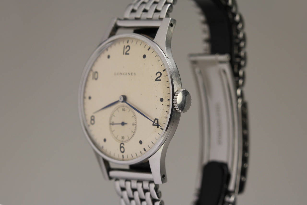 This is an incredible example of a large stainless steel Longines wristwatch from the 1950s. It is similar to the Patek Philippe Calatrava Ref 570. The watch is in mint condition with an unpolished case and original dial.