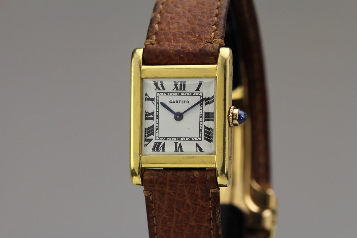 This is an 18k yellow gold Cartier Tank Normale wristwatch from the 1940s. It has a European Watch & Clock movement which is the most collectible movement for Cartier enthusiasts. The watch is in original condition with proper Cartier numbers to the