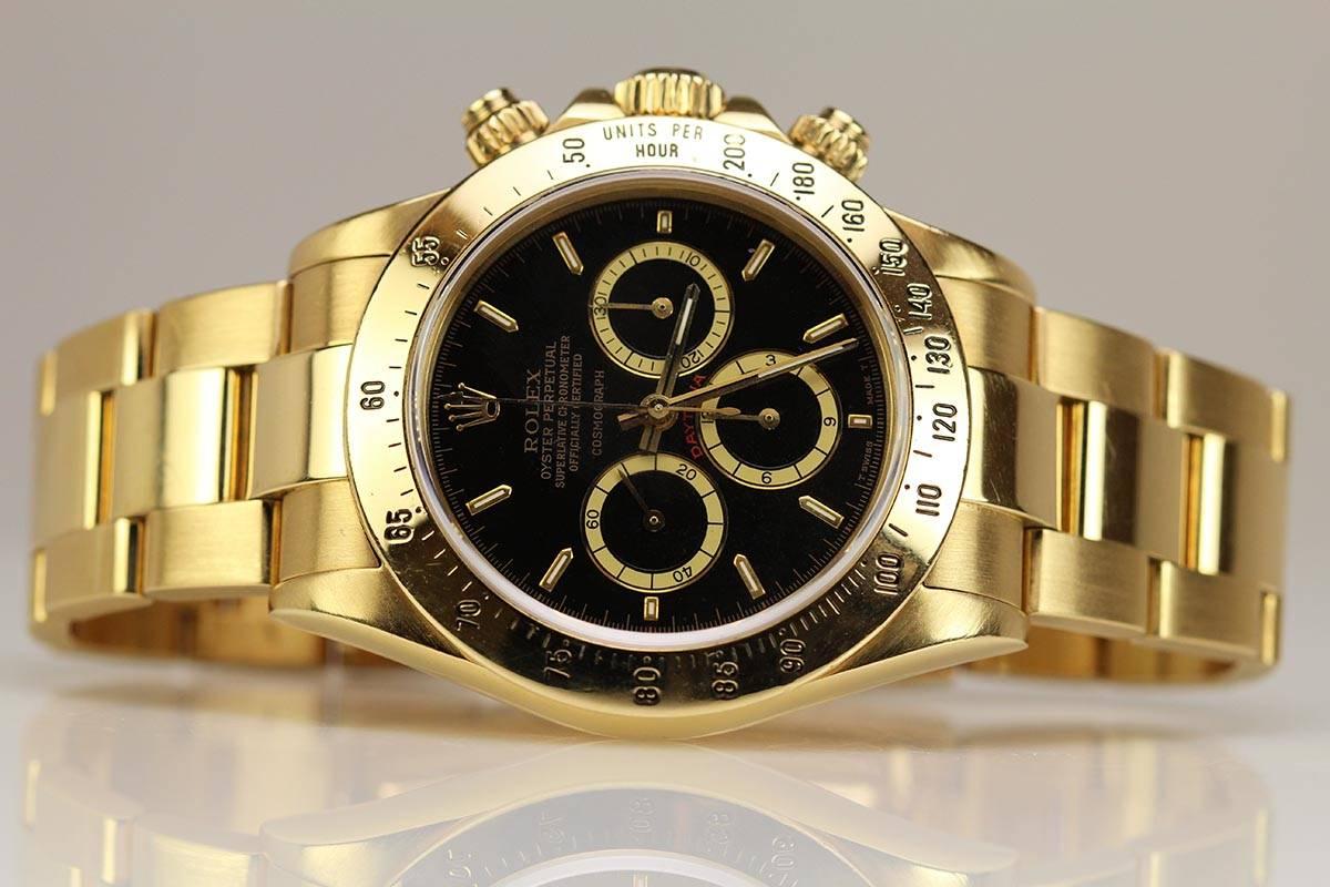 This is a beautiful Rolex Cosmograph Daytona in yellow gold with gold bezel, black 