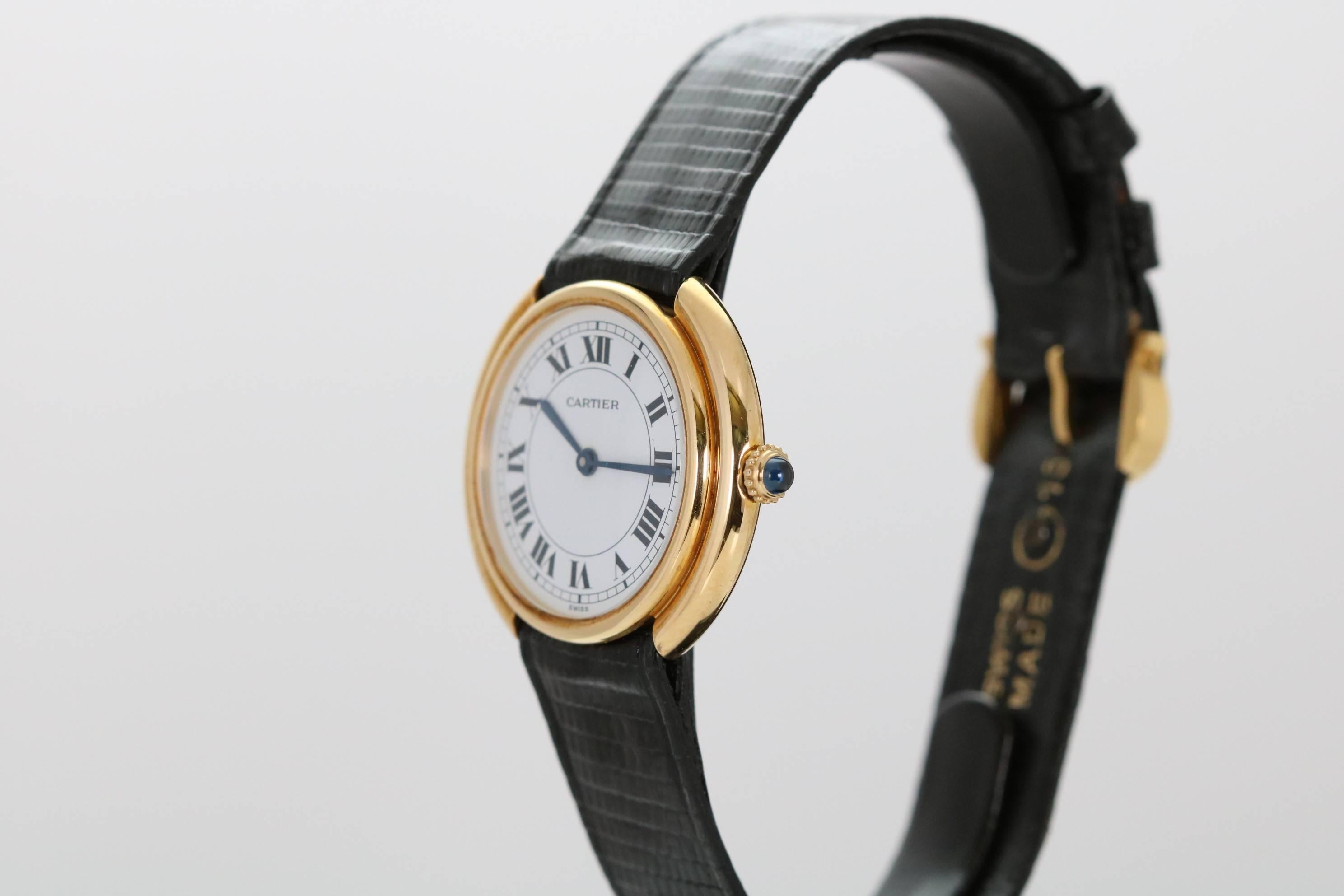 This is a elegant Cartier oval stepped case with an automatic movement and is on a Cartier strap and tank buckle.
