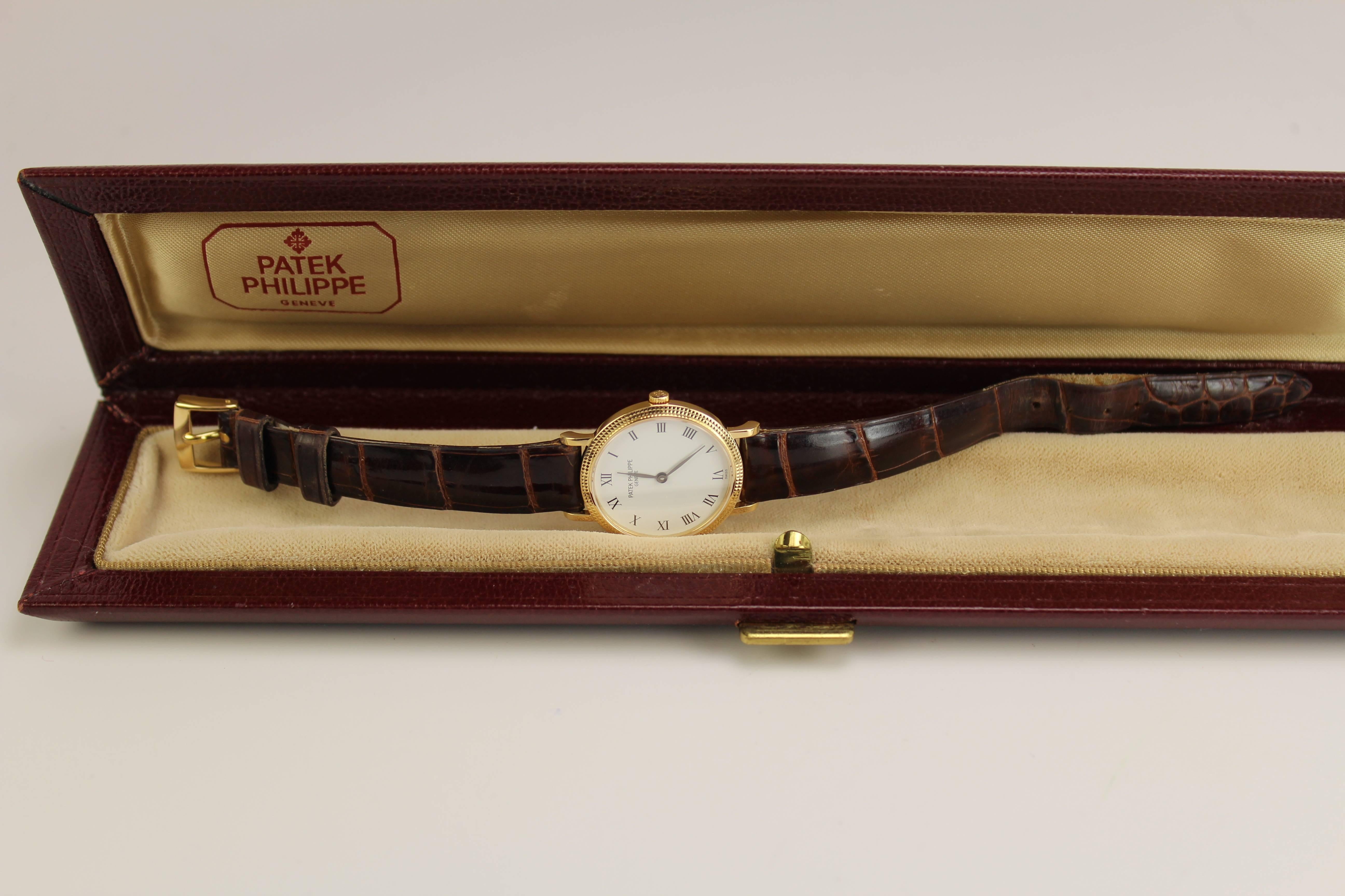 This is a classic Patek Philippe lady's Calatrava with a hobnail case, original strap with buckle, and is run with a quartz movement. Comes with box.
