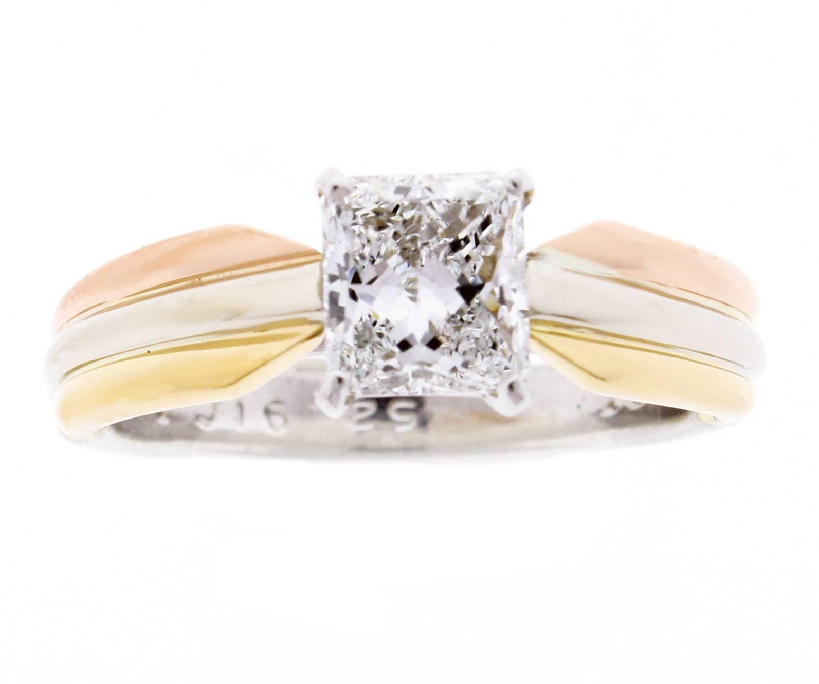 Three bands. Three colors. Pink gold, yellow gold and platinum, intertwined in a display of mystery and harmony.  The iconic Cartier Trinity engagement ring set with a stunning radiant cut diamond weighing .91 carat, F color and VS2 clarity. G.I.A.