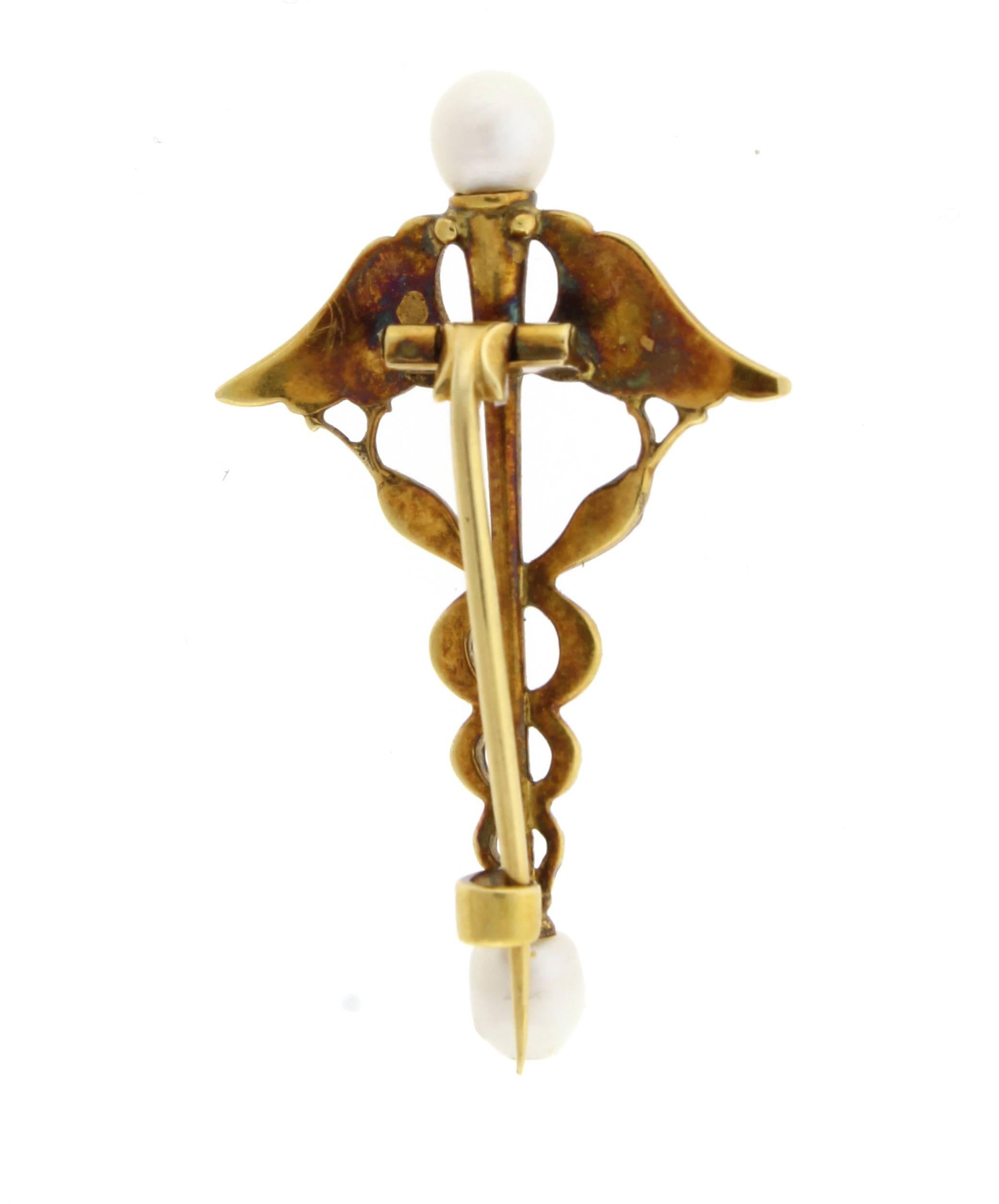 From master jewelers Carlo and Arthur Giuliano, an caduceus brooch. The 18 karat brooch is comprised of a center scepter with intertwined serpents terminated with natural pearls.  The brooch is beautifully enameled and in original condition.
1 1/2