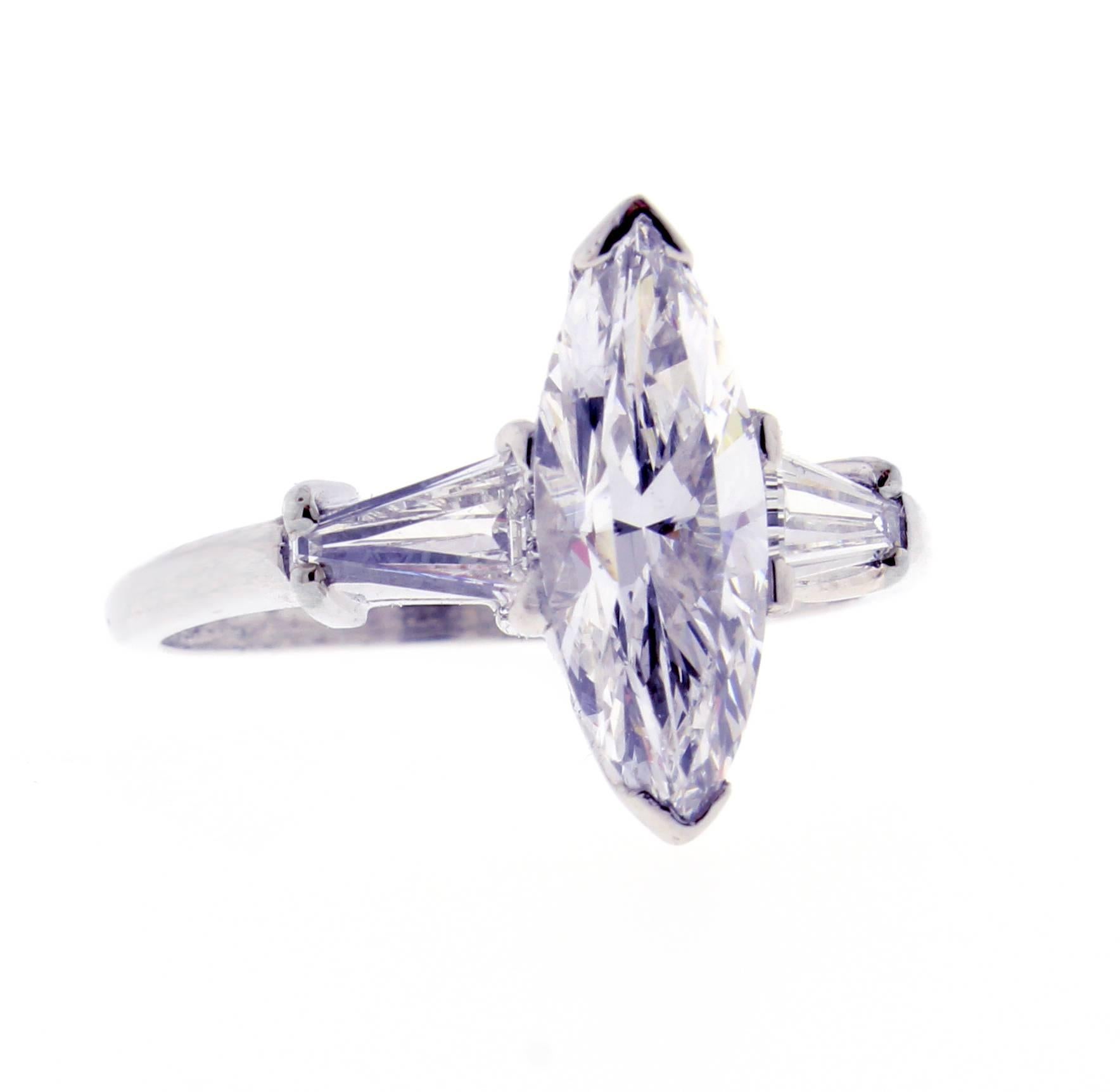 The G.I.A certified Marquise cut diamond weighs 1.80 carat. The diamond is D Color and VS2 clarity. The two tapered baguettes weigh approximately .75 carats total. Set in platinum, size 7 ¼ adjustable. Circa 1965