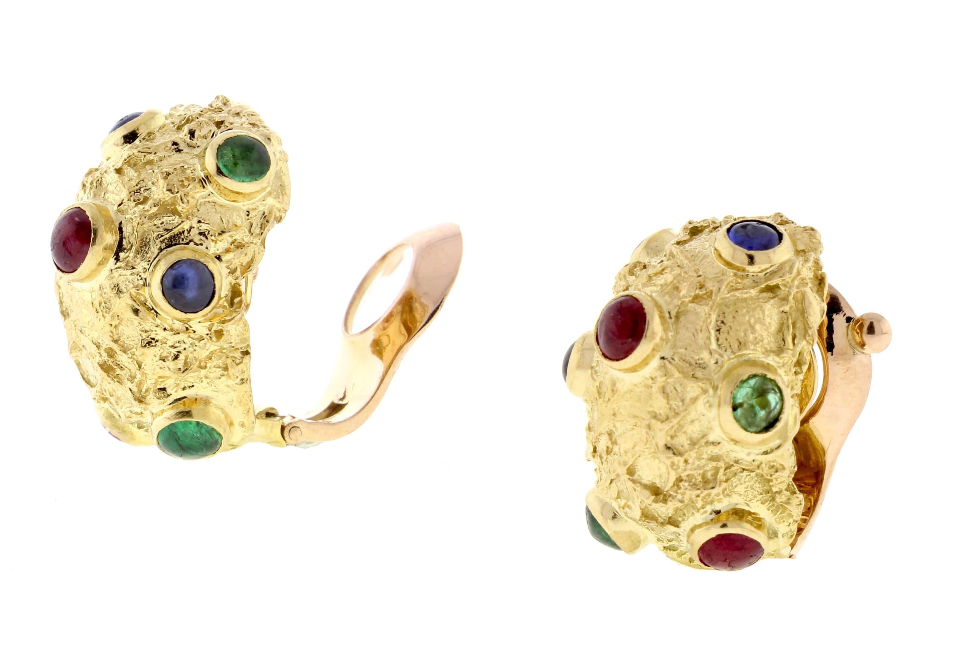 From Van Cleef and Arpels, a pair of textured  18 karat gold hoop earrings set the cabochon rubies, sapphires and emeralds. The hoops measure 5/8 of an inch across and 7/8 high, 16.7 grams. Signed and numbered, made in France