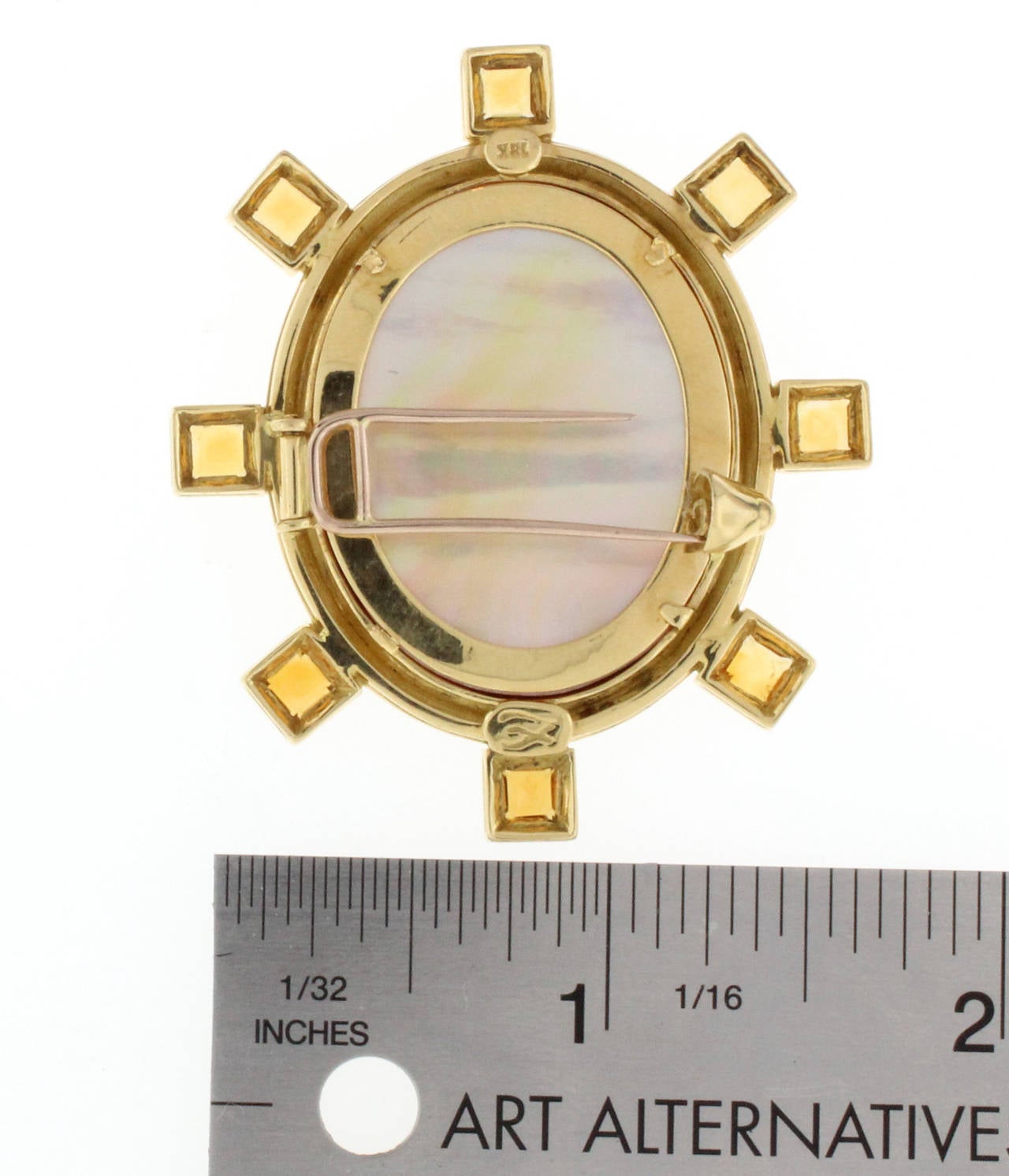 This Elizabeth Locke brooch is 19 karat yellow gold and features maroon Venetian glass with a colonial intaglio.  The brooch also features 8 square citrines around the center oval Venetian glass. The brooch measures 2 inches long by 1.75 inches in