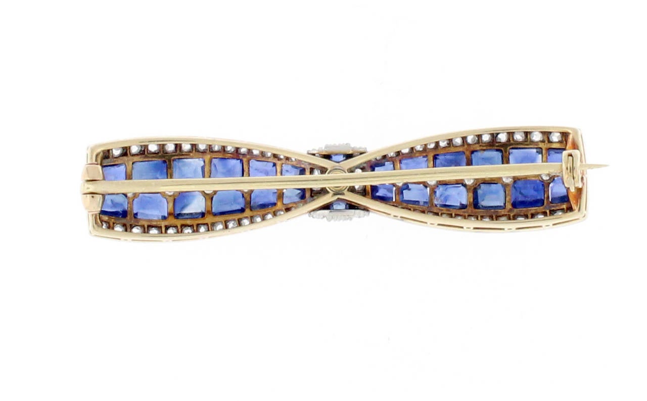 This Antique Sapphire and Diamond Bow Brooch is circa 1915. The brooch contains 2.35 carats of sapphires and .70 carats of diamonds. The brooch is made in platinum and 14 karat yellow gold.