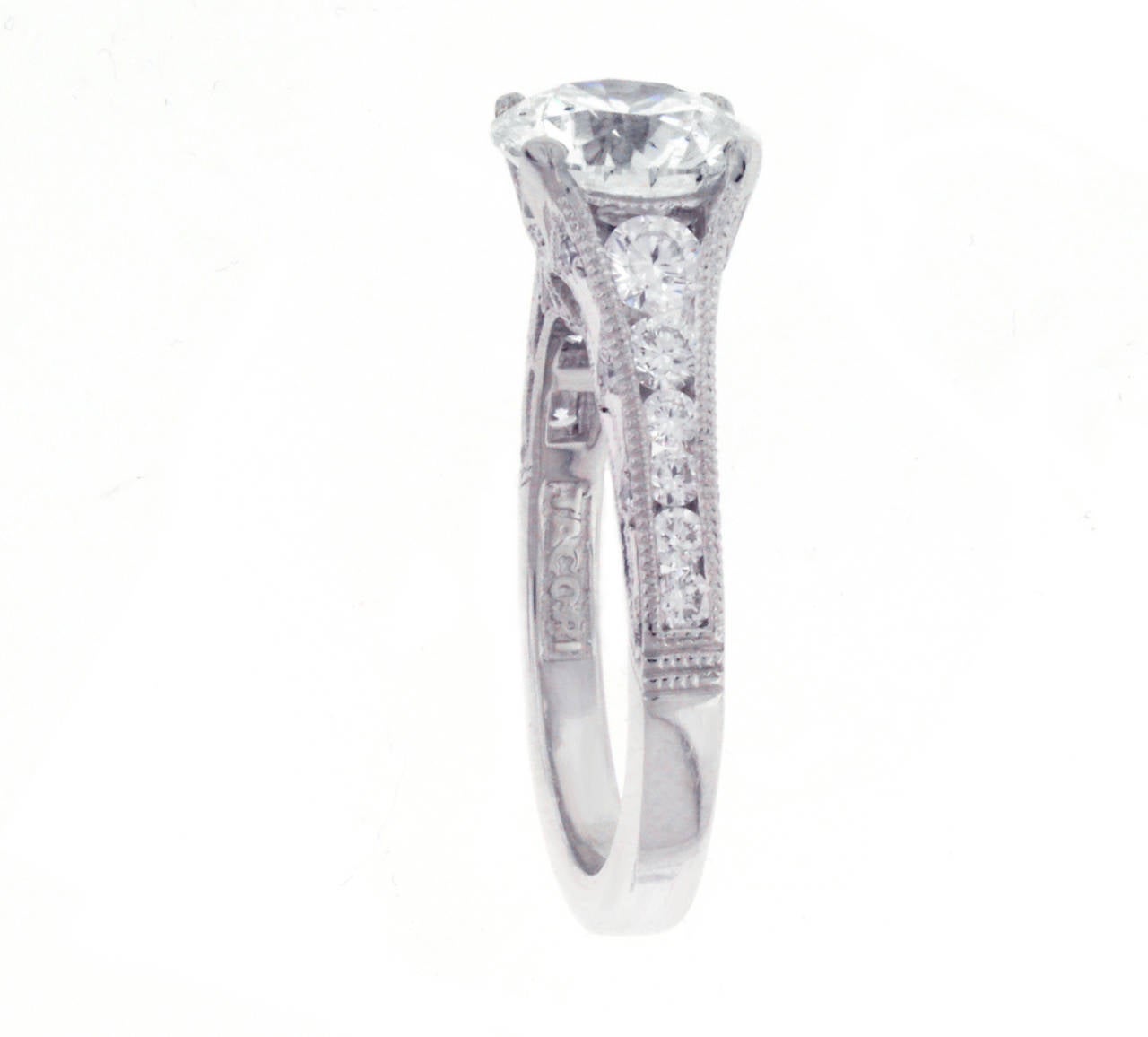 This Tacori diamond engagement ring features a 1.96 carat center round brilliant diamond. The diamond is I color, I1 clarity with excellent polish, symmetry and cut. The center diamond is accented by .60 carats of round diamonds going down the band