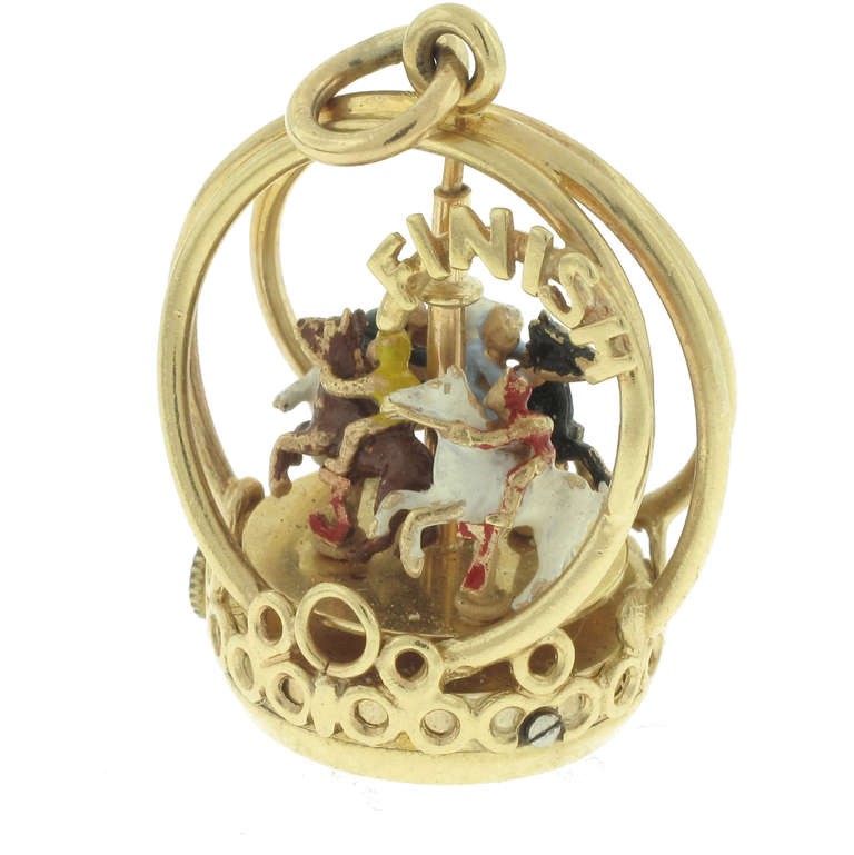 This Henry Danker Carousel Charm features a carousel that actually winds up and twirls around on its own. It is made of 14 karat yellow gold. There are 4 painted horses and riders on the carousel. The charm is .75