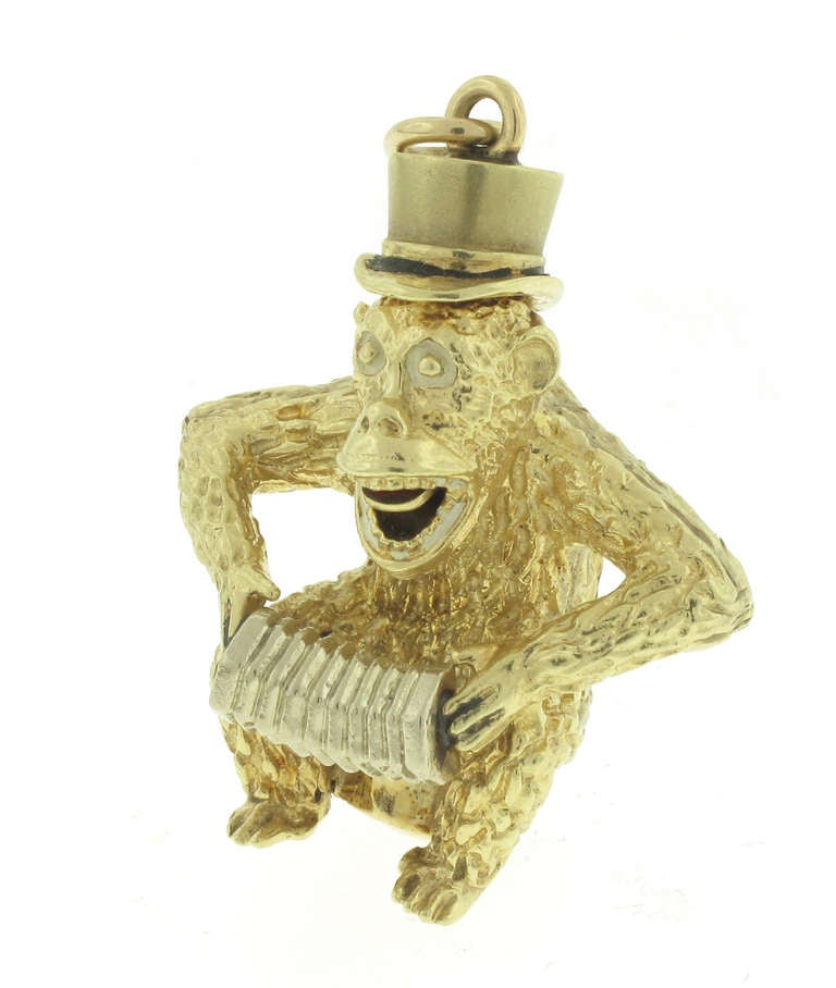This Henry Danker charm depicts a monkey. If you push his tail down his top hat pops up and he sticks his tongue out. It is made of 14 karat yellow gold. The charm is 1