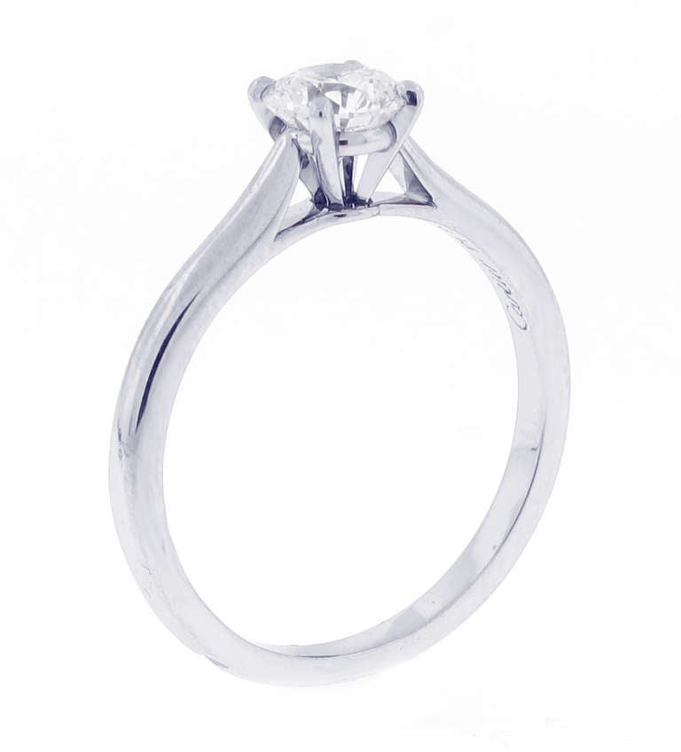 This solitaire has been a Cartier classic since 1895. The elegance of the lines is unique, the refined and light setting allows the light of the diamond to flow freely.

This ring features a .70 carat round brilliant cut diamond H color, VS1