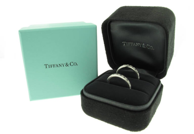 These Tiffany & Co. Legacy Platinum Sapphire and Diamond Bands features 2 round brilliant cut diamonds with a total carat weight of .20 carats and 21 blue sapphires with a total weight of .26 carats. The diamonds are color 